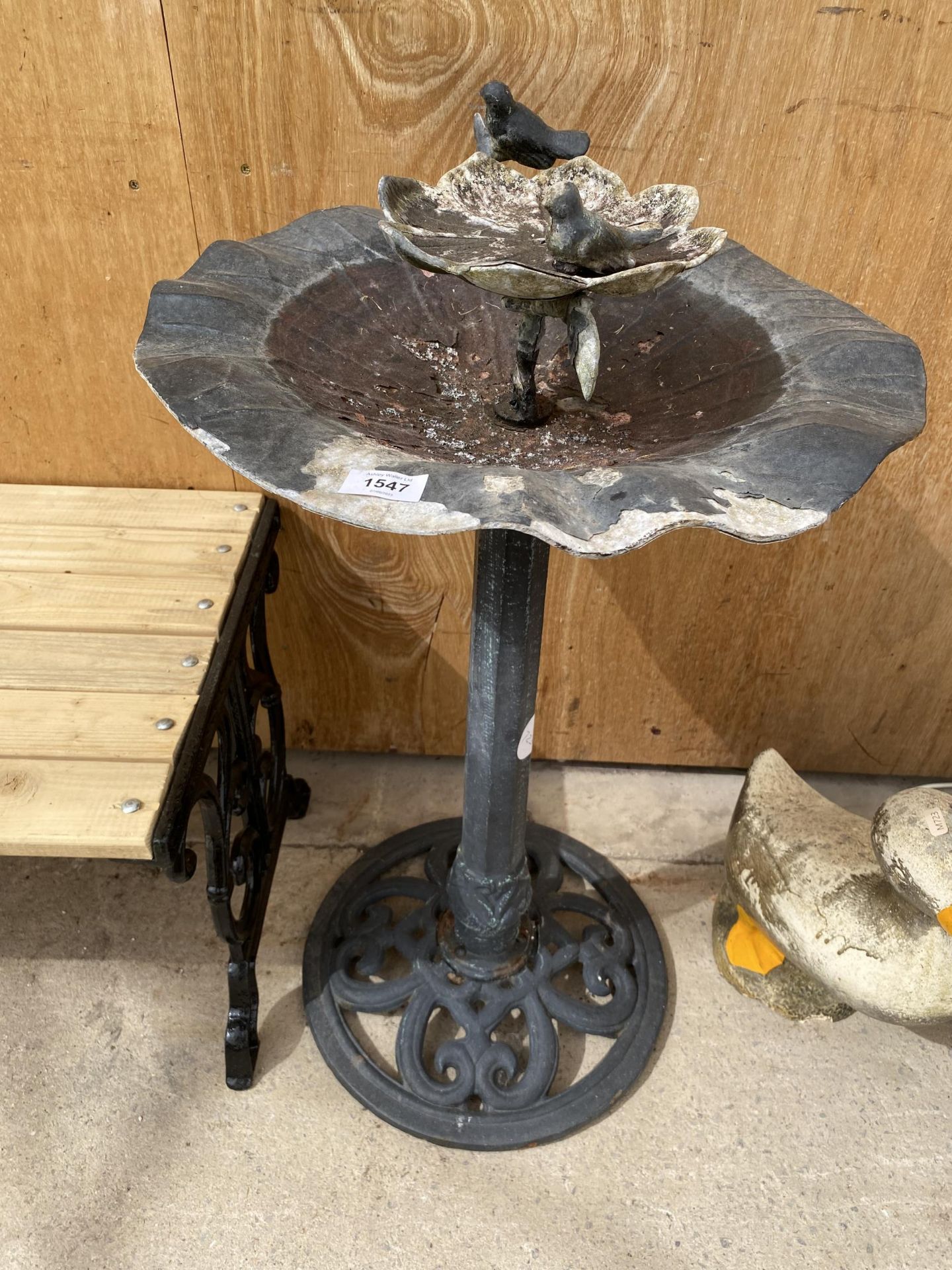 A DECORATIVE CAST ALLOY BIRD BATH WITH CAST IRON PEDESTAL BASE