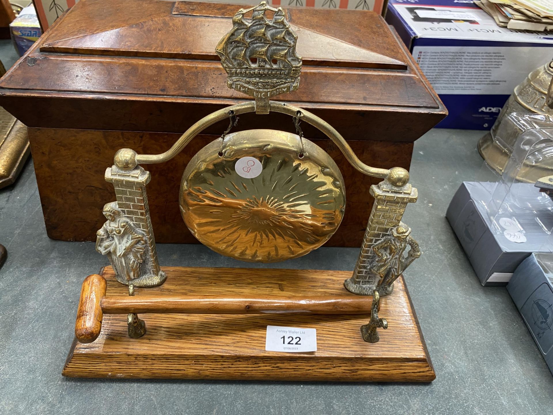 A VICTORIAN BRASS GONG AND HAMMER ON AN OAK BASE WITH HMS VICTORY MOTIF