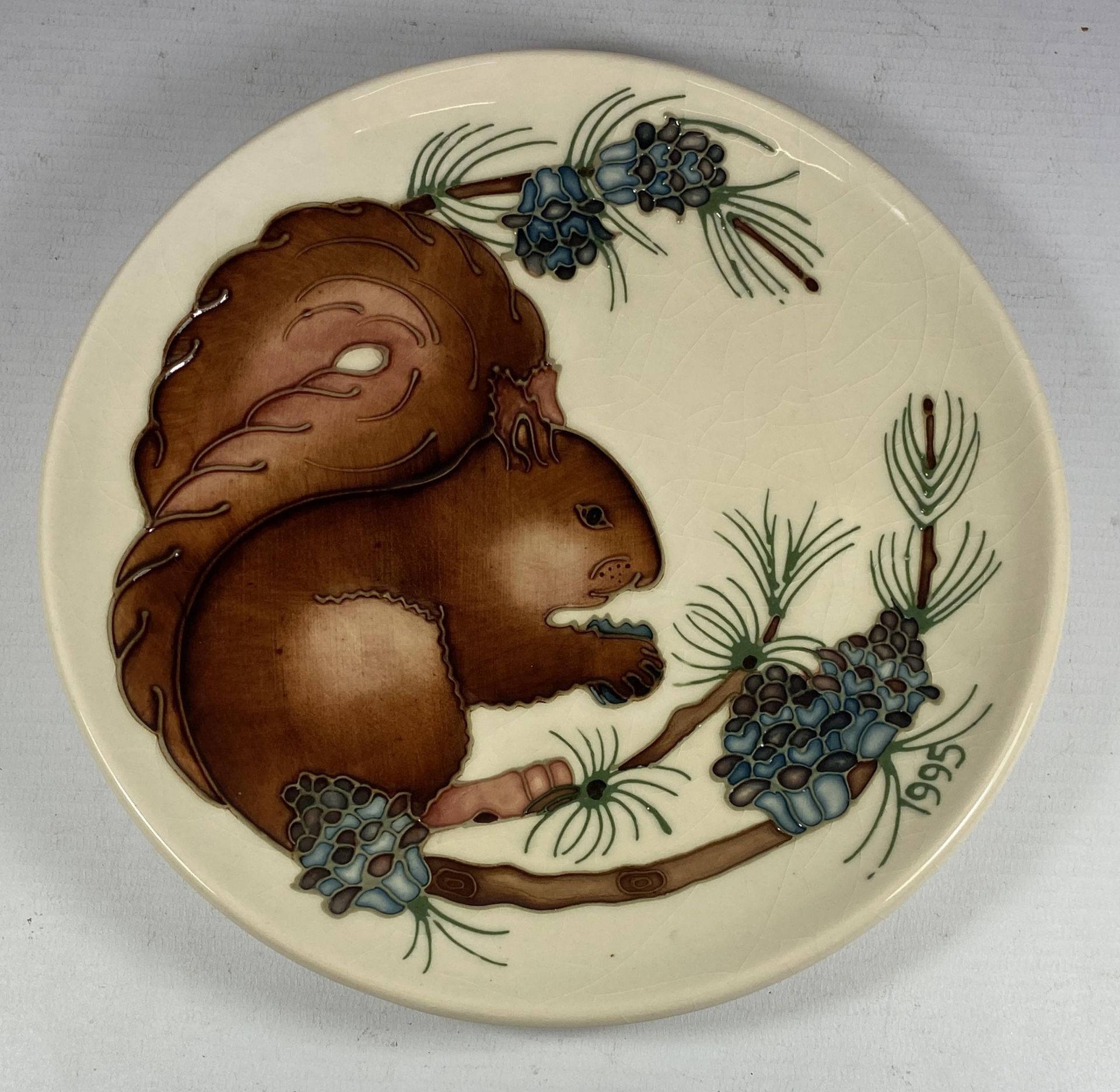 A LIMITED EDITION MOORCROFT POTTERY SQUIRREL PATTERN PLATE, NUMBER 330/500, 1995