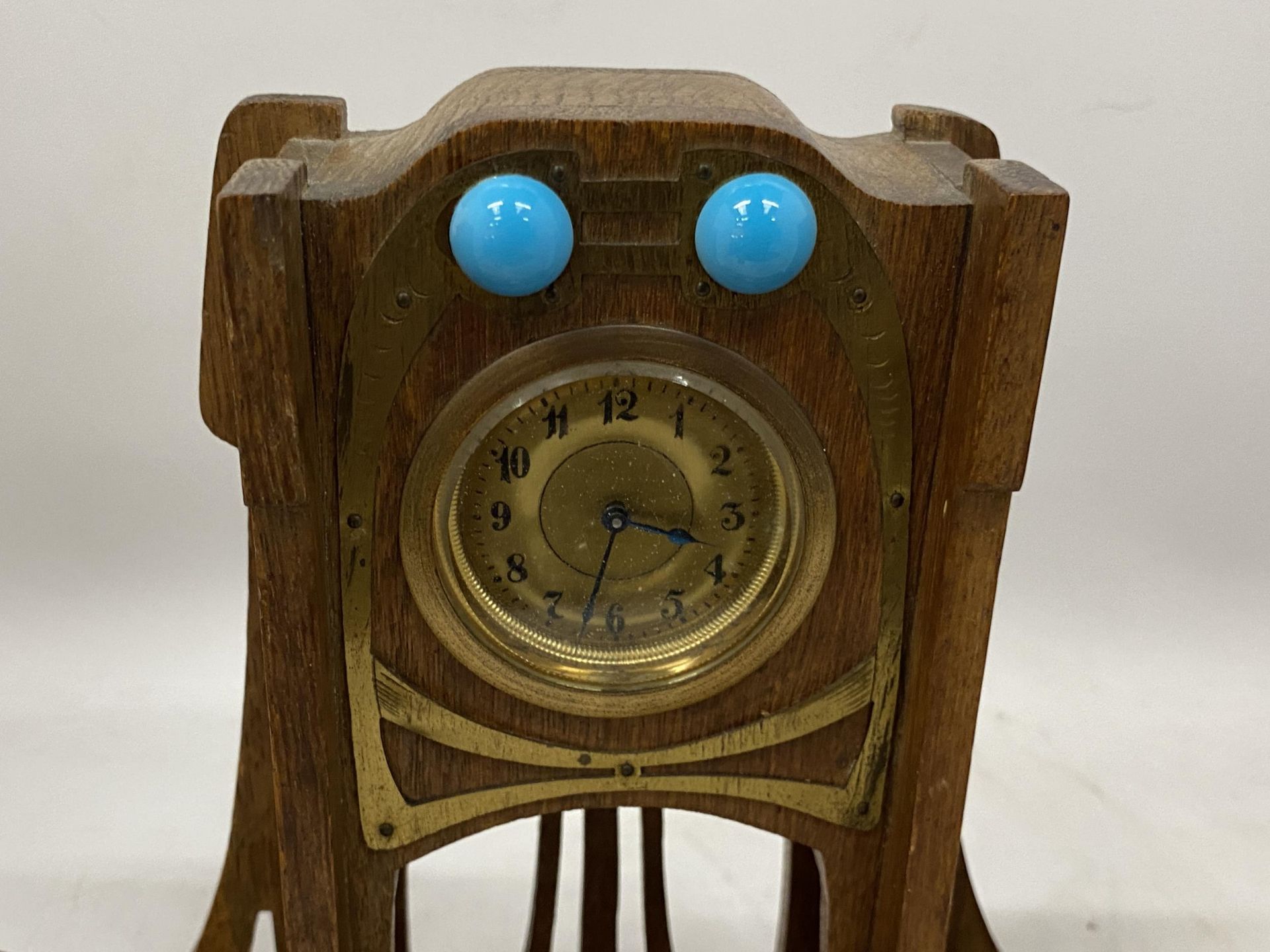 AN ARTS AND CRAFTS WOODEN CLOCK WITH INSET INKWELLS - Image 2 of 3