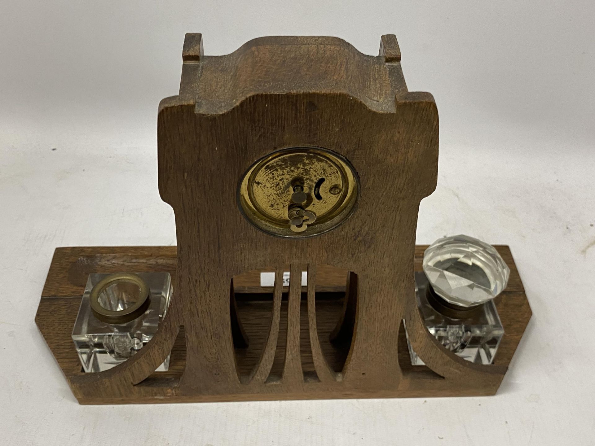 AN ARTS AND CRAFTS WOODEN CLOCK WITH INSET INKWELLS - Image 3 of 3