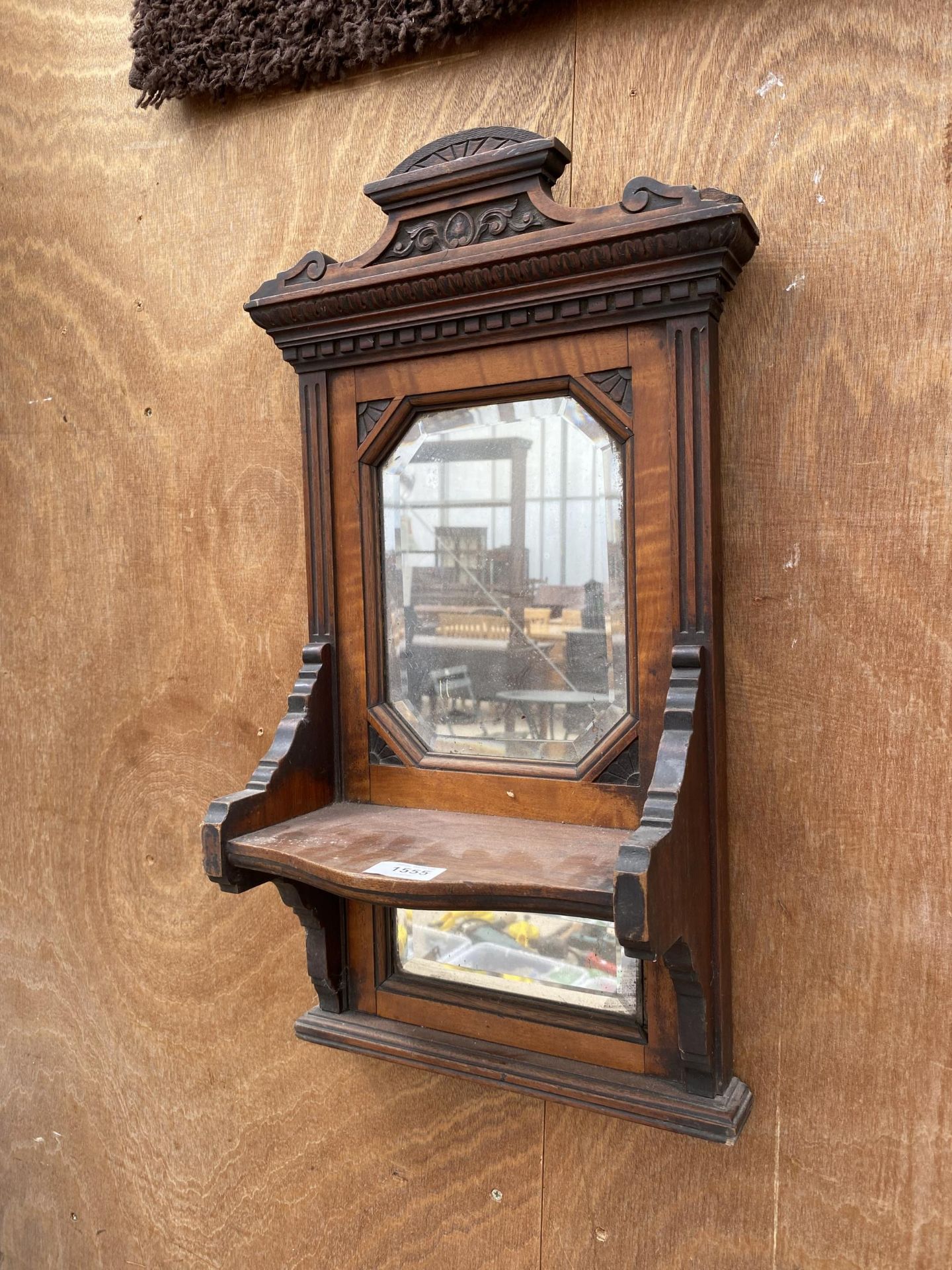 A WOODEN WALL MIRROR WITH LOWER SHELF AND FURTHER LOWER MIRROR