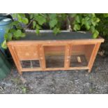 A WOODEN RABBIT HUTCH WITH MESH FRONT