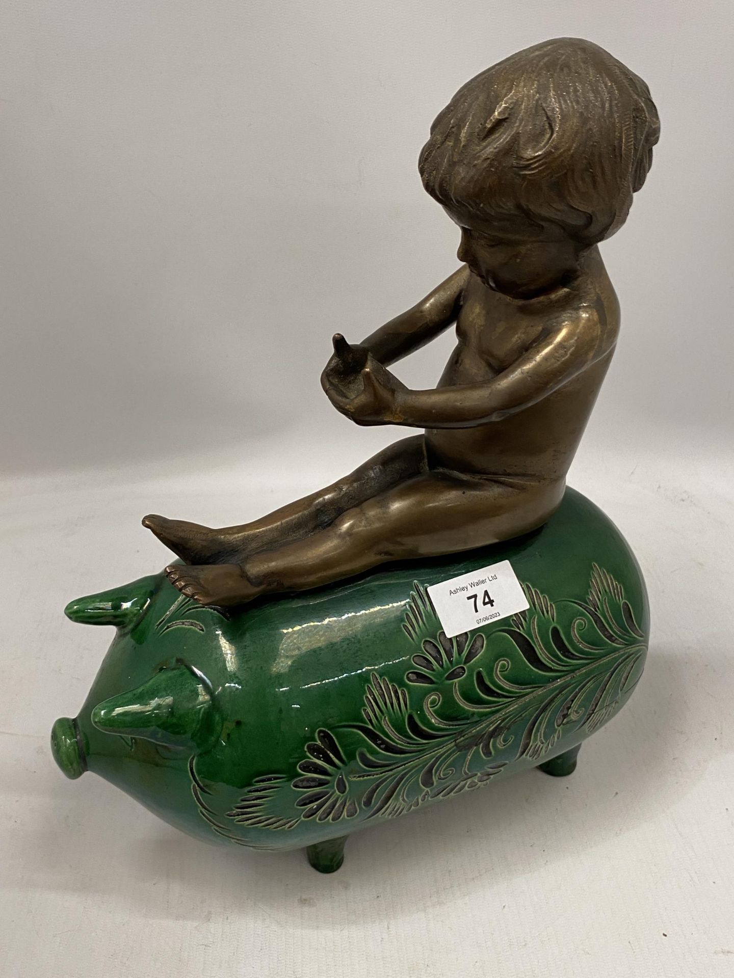 A GREEN VICTORIAN CERAMIC PIG WITH BRONZE MODEL OF A BOY SEATED, HEIGHT 34CM