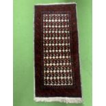 A SMALL WOOLLEN RUG 88CM X 43CM