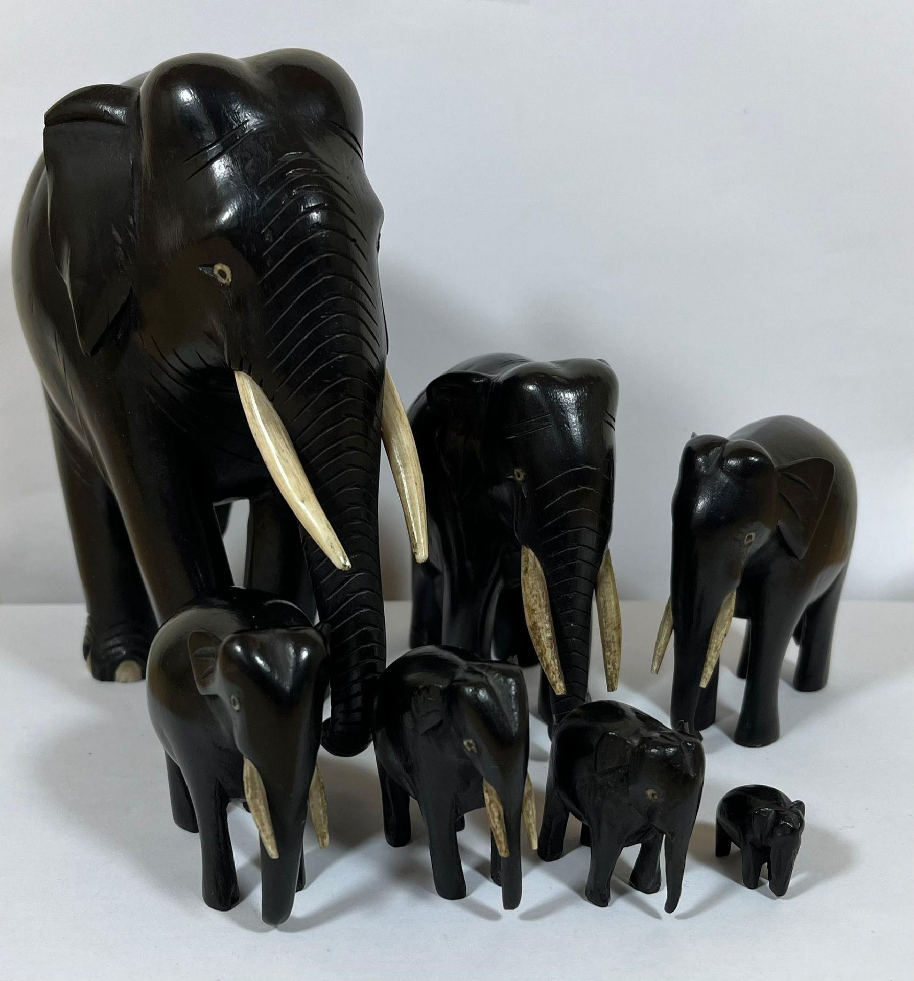 AN ANTIQUE FAMILY OF SEVEN GRADUATED EBONY ELEPHANTS, LARGEST 16CM, SMALLEST 1.5CM