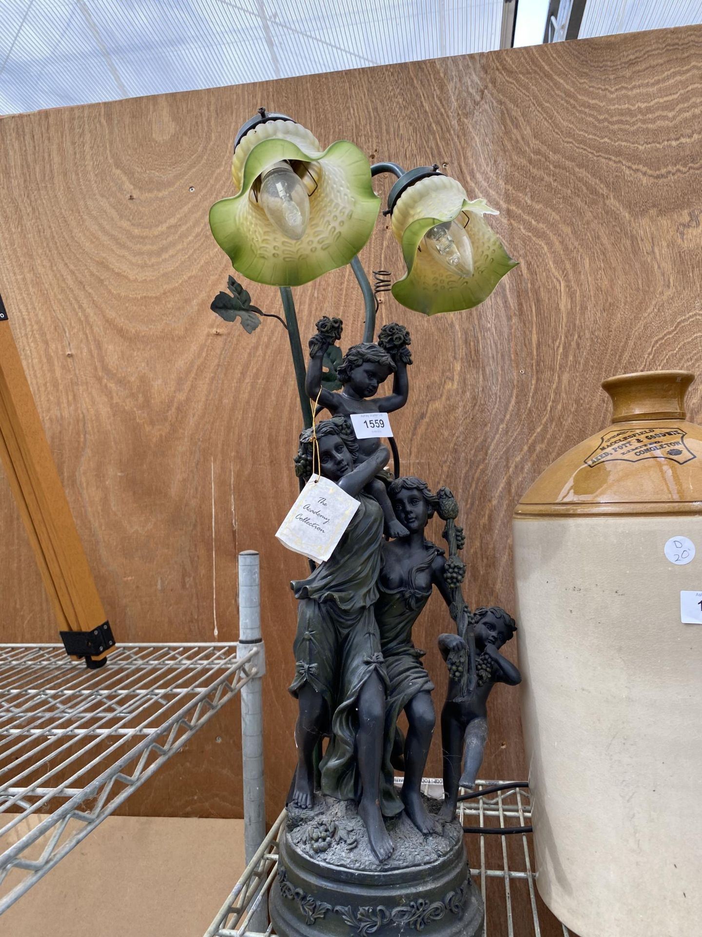 A DECORATIVE METAL TABLE LAMP WITH CHERUB DESIGN AND GREEN GLASS SHADES (ONE SHADE A/F)