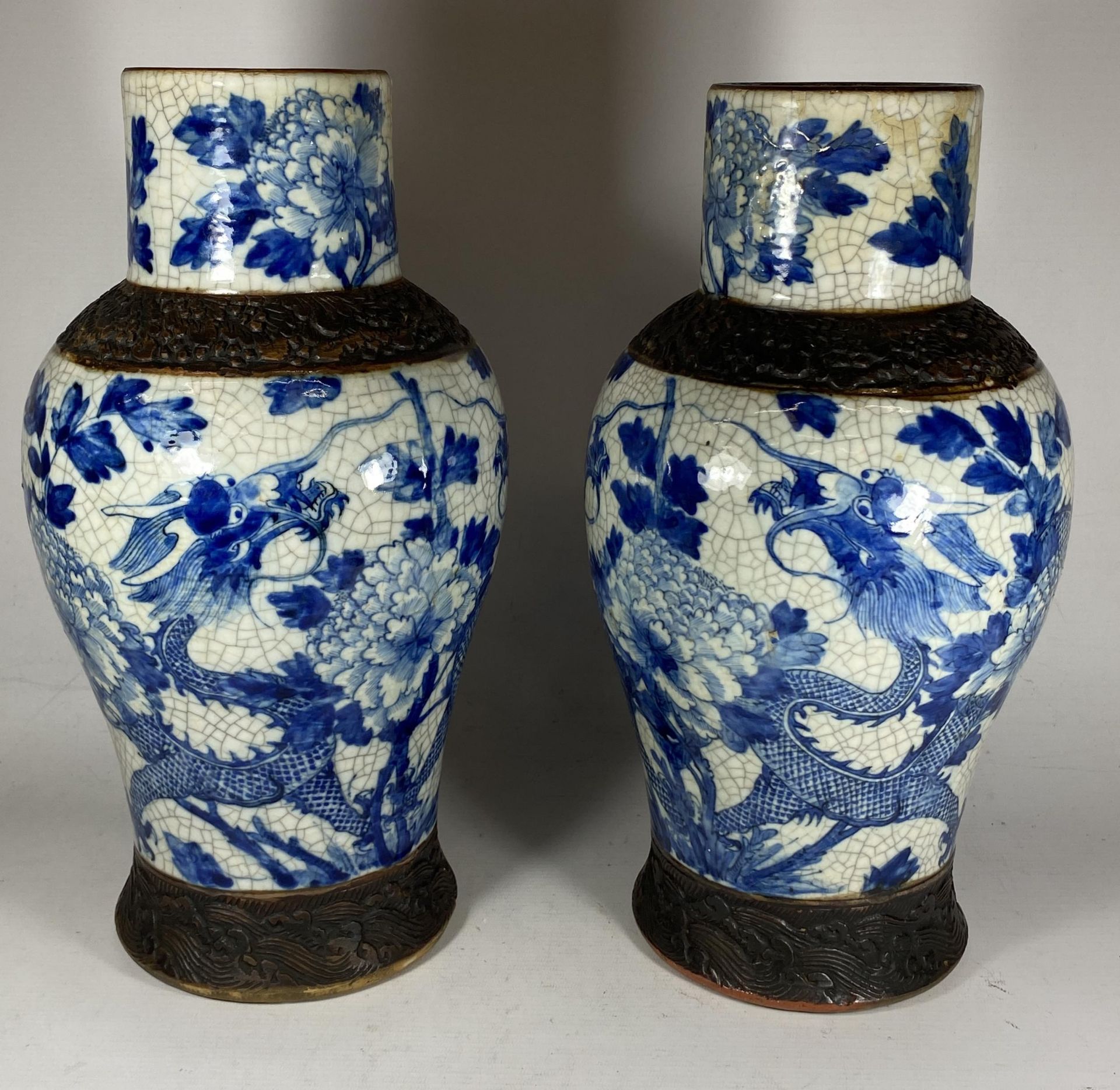 A PAIR OF EARLY 20TH CENTURY CHINESE BLUE AND WHITE CRACKLE GLAZE DRAGON DESIGN VASES, A/F, HEIGHT