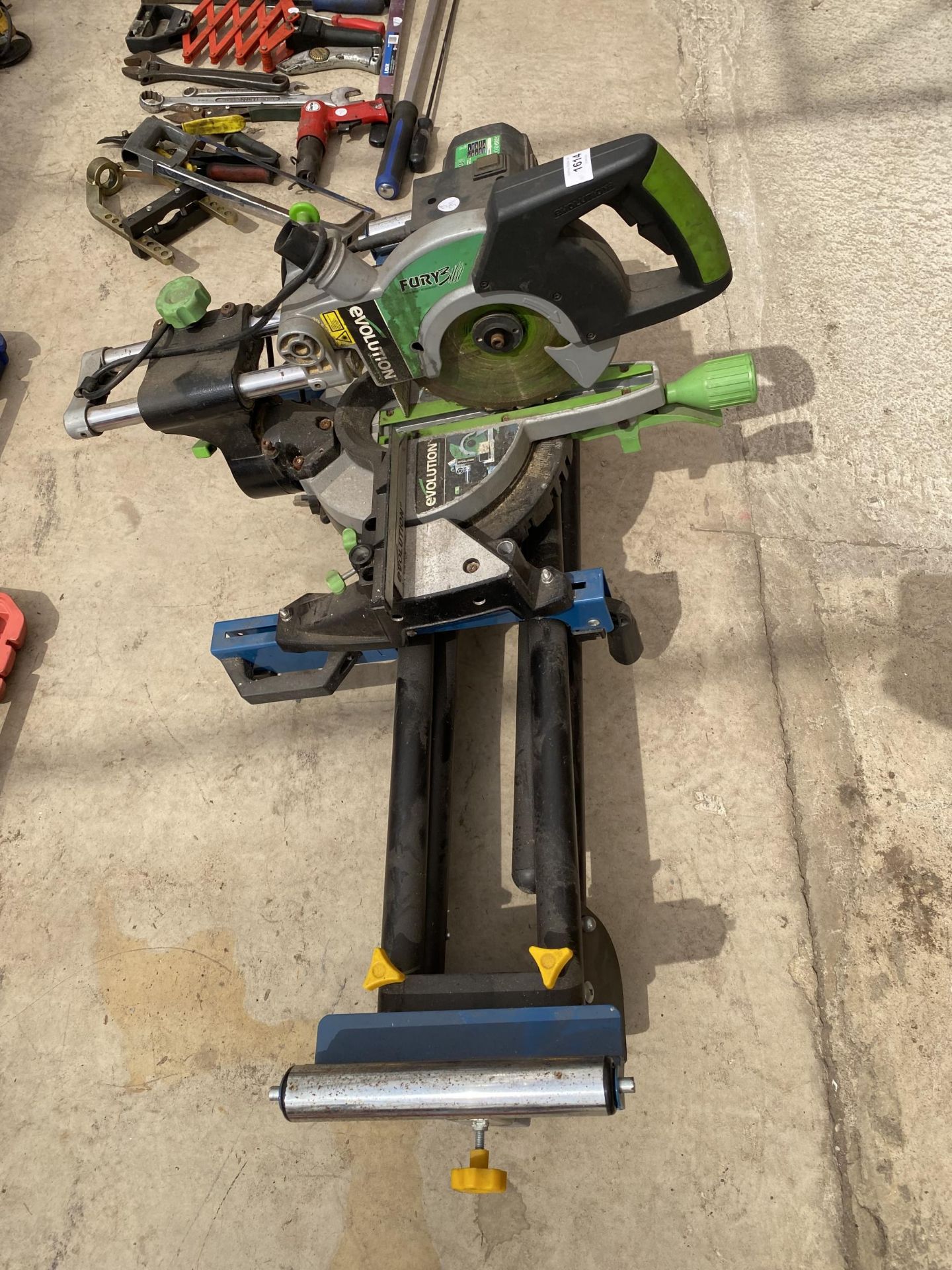 AN EVOLUTION ELECTIC MITRE SAW AND A WORKZONE WOOD ROLLER STAND