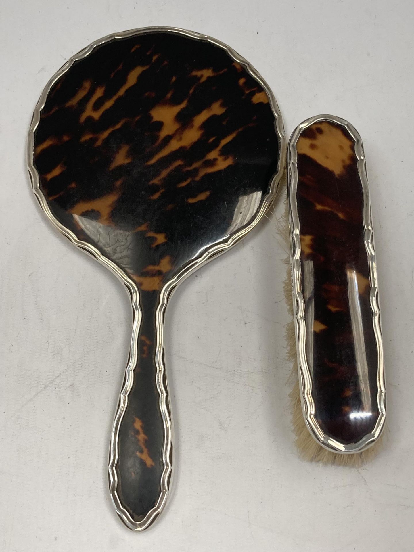 A HALLMARKED SILVER AND TORTOISESHELL EFFECT HAND MIRROR AND BRUSH