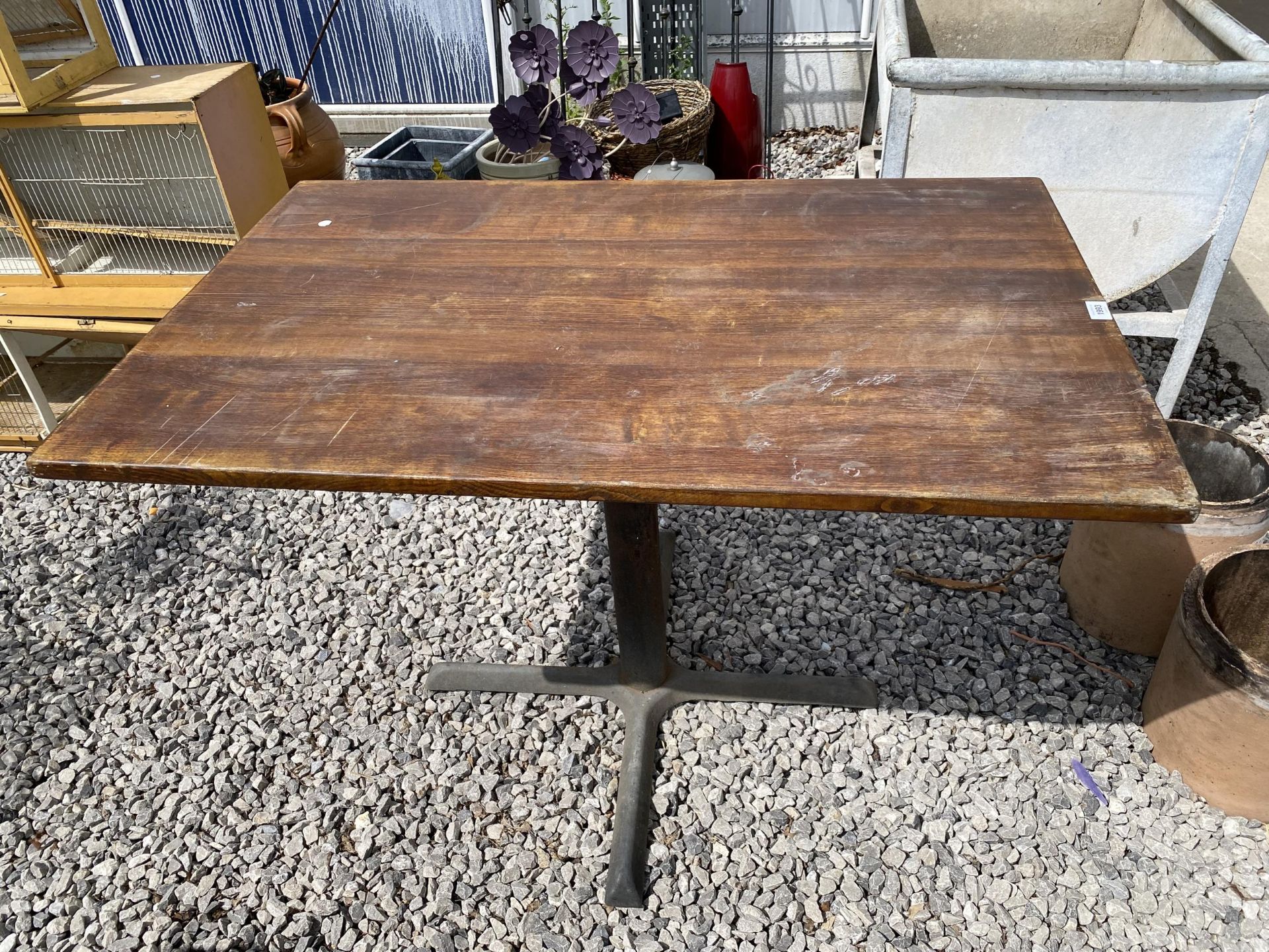 A WOODEN TOPPED PUB TABLE WITH CAST IRON BASE