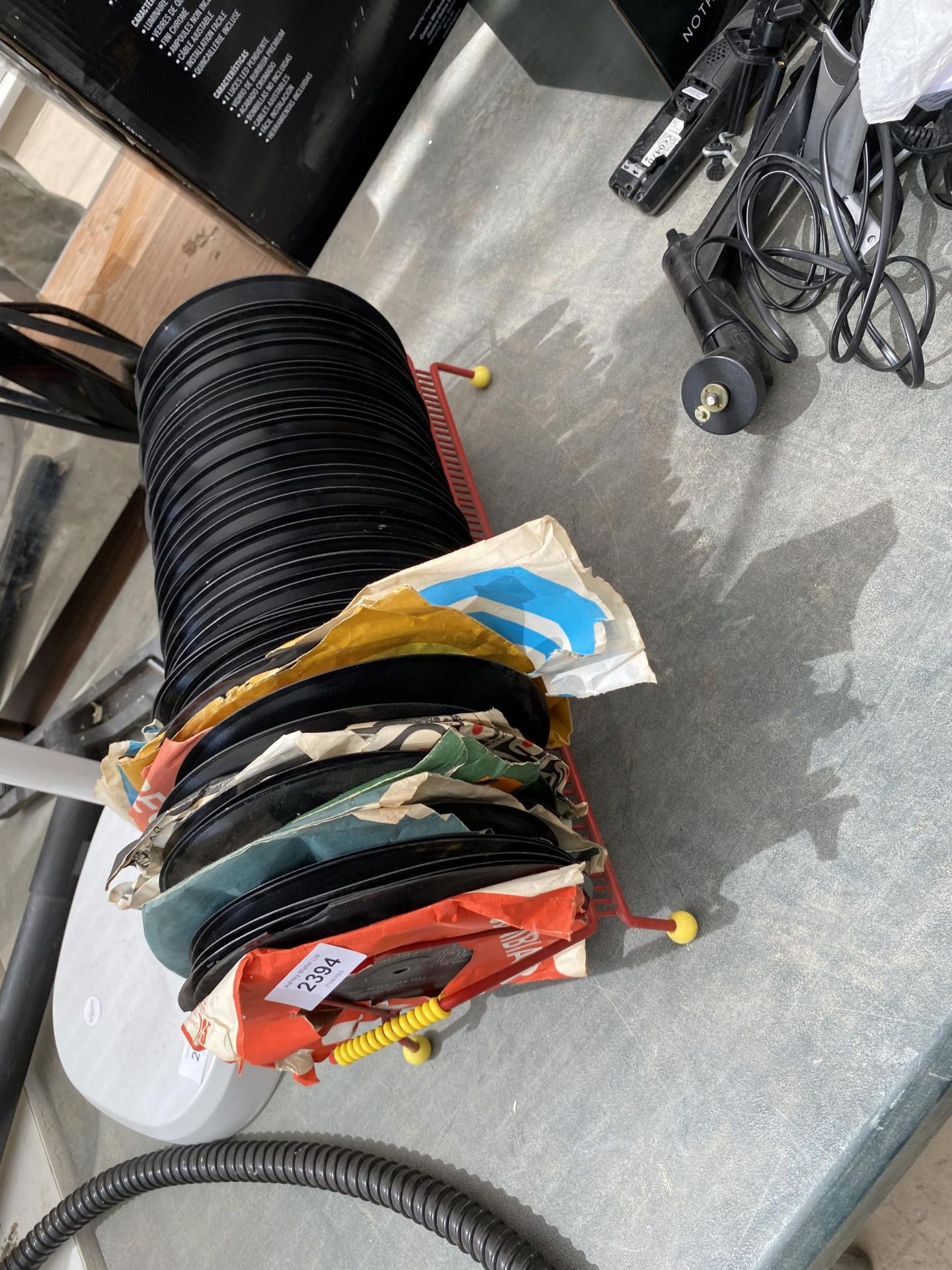 A SPUTNIK STYLE RECORD RACK WITH AN ASSORTMENT OF 7" SINGLES