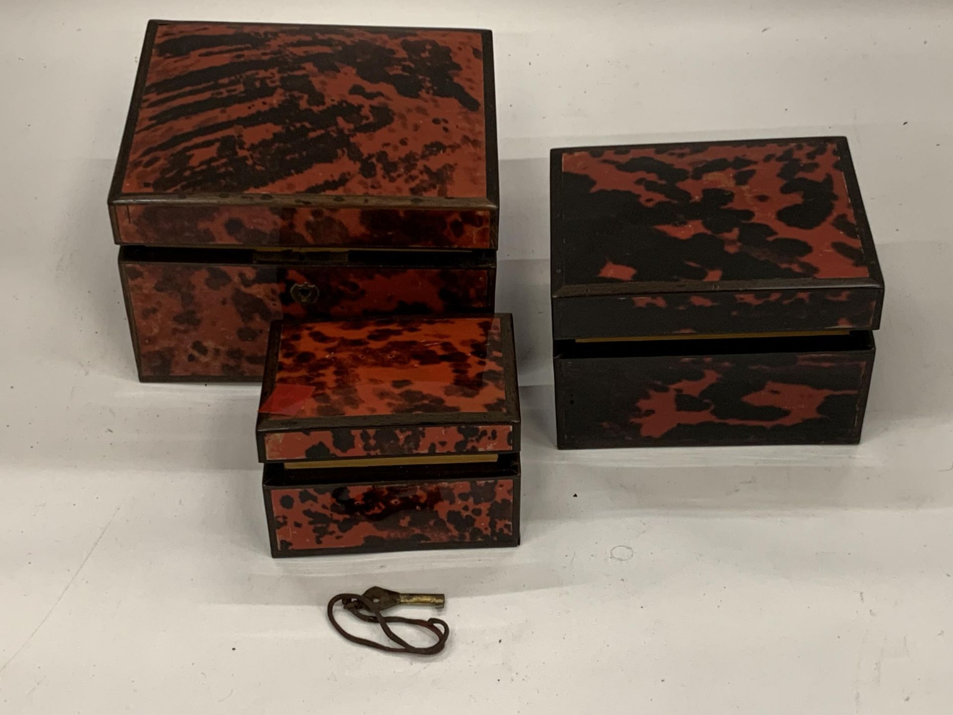 A SET OF THREE GRADUATED TORTOISESHELL EFFECT JEWELLERY BOXES