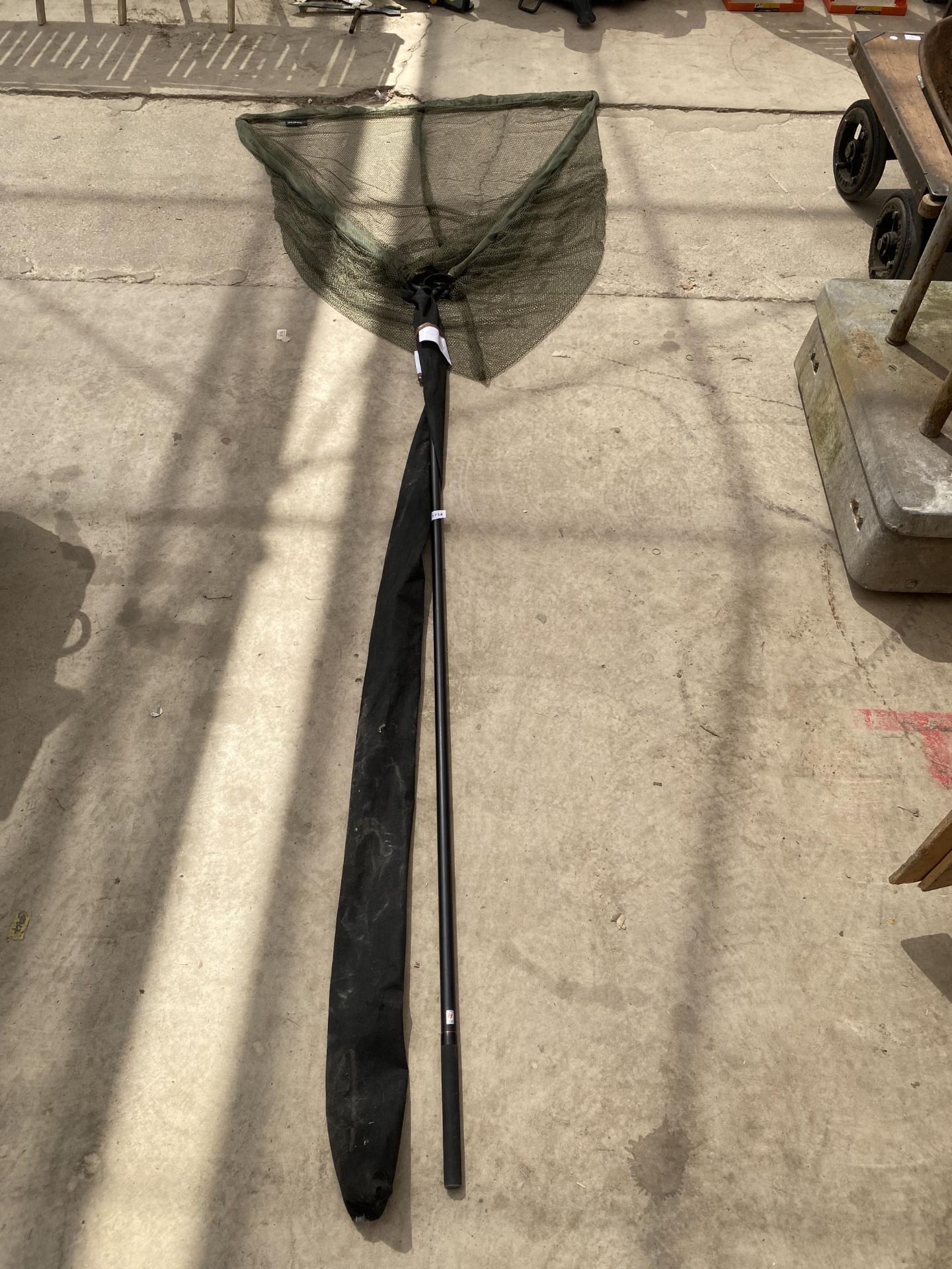 A LARGE LANDING NET AND THREE SECTION FISHING ROD