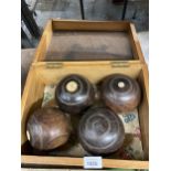 A VINTAGE PINE BOX CONTAINING FOUR BOWLING BOWLS