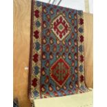 A VINTAGE RED AND BLUE PATTERNED RUG