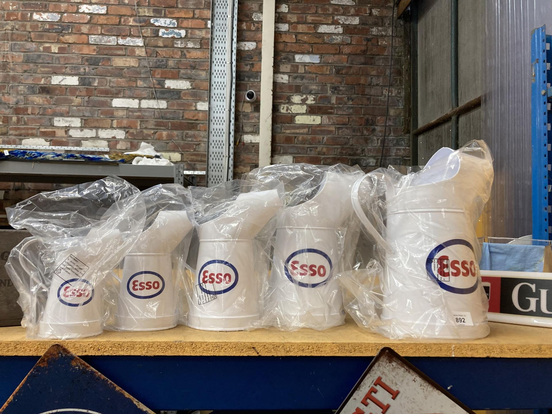 A SET OF FIVE WHITE GRADUATED 'ESSO' OIL CANS