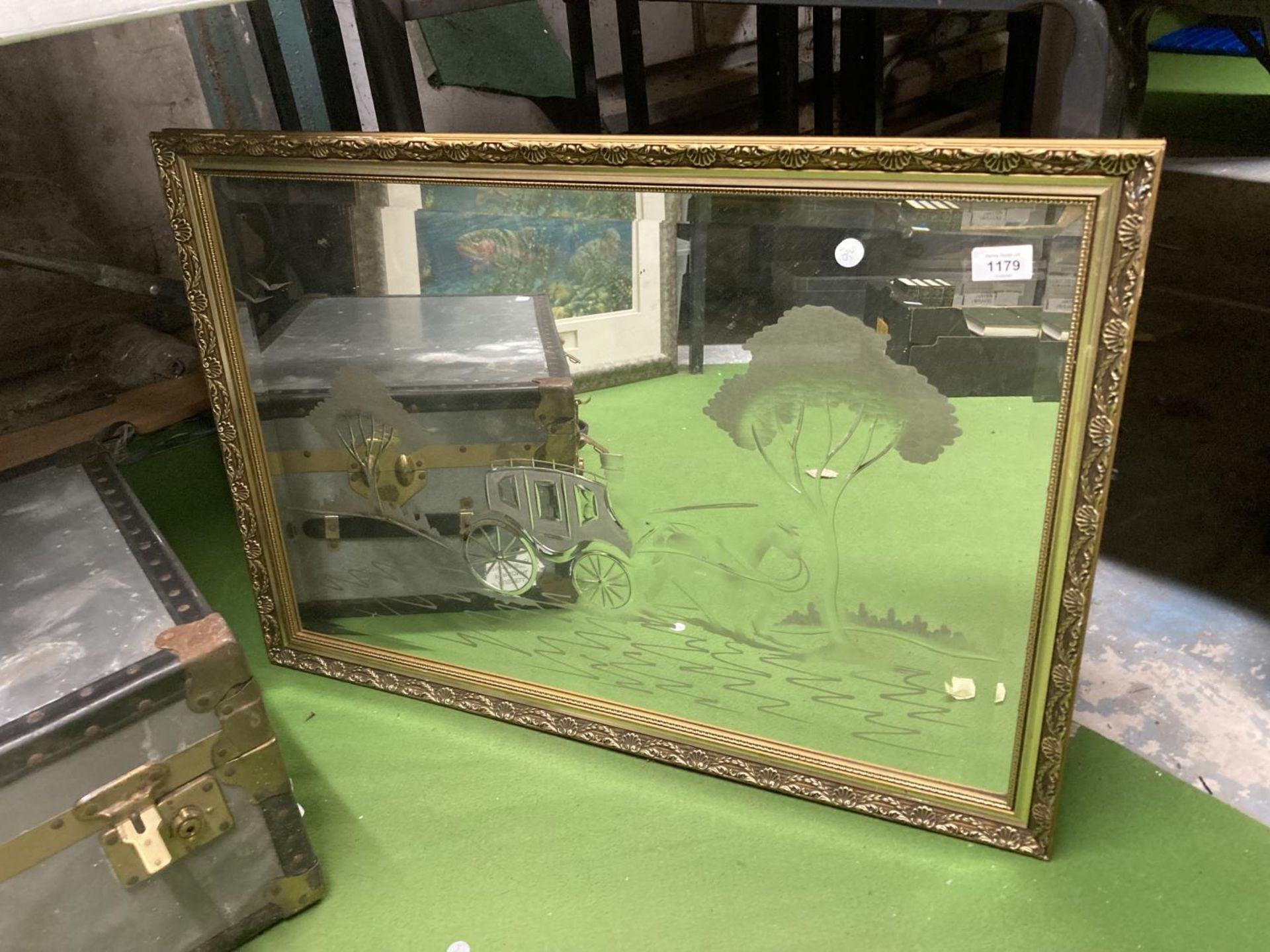 A GILT FRAMED MIRROR WITH ETCHED CARRIAGE SCENE