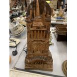 A VINTAGE WOODEN CARVING OF A CASTLE WITH A CREATURE UNDERNEATH SIGNED SOUDANI, HEIGHT 45CM