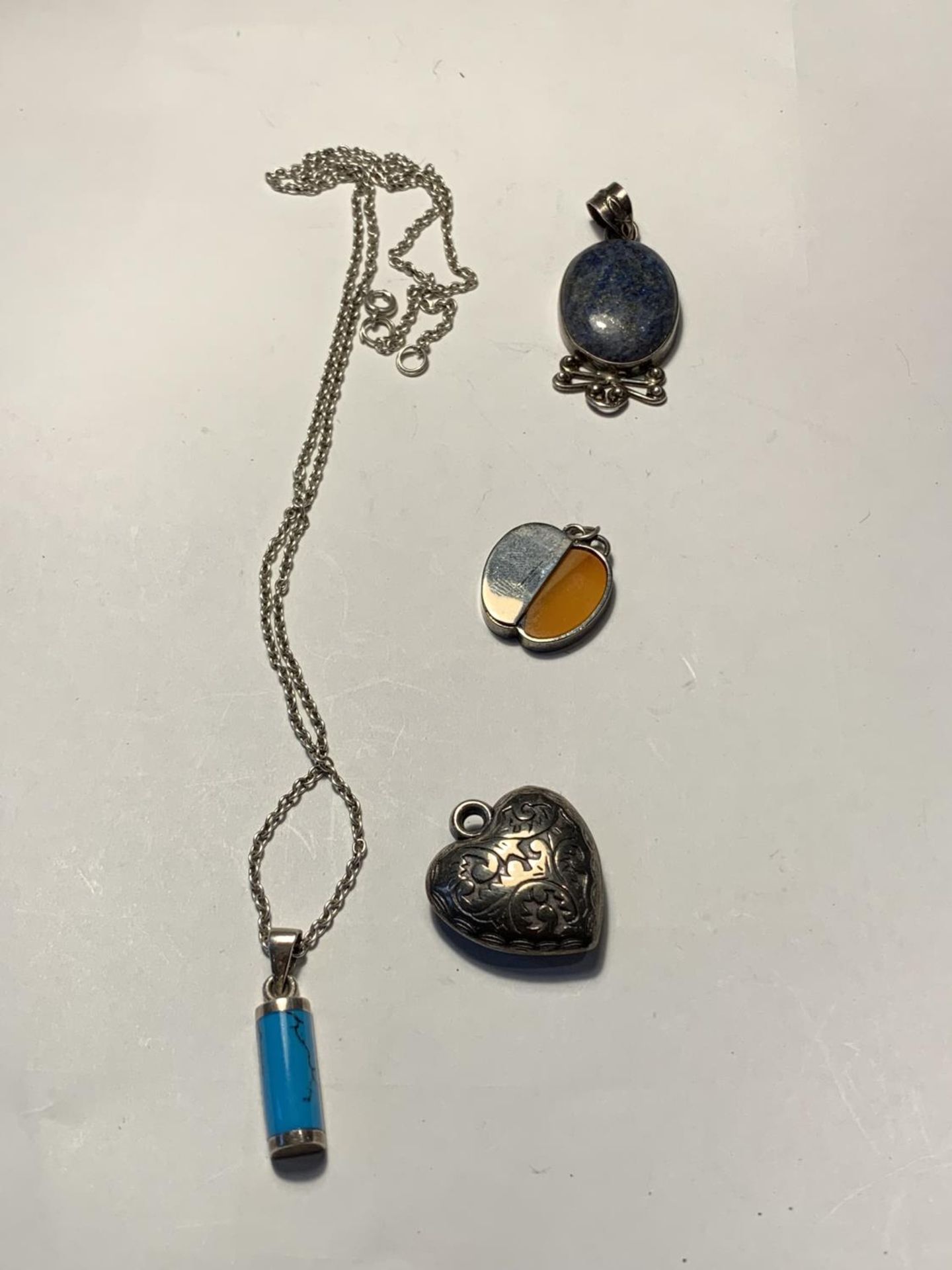 A SILVER NECKLACE WITH PENDANT AND THREE FURTHER PENDANTS