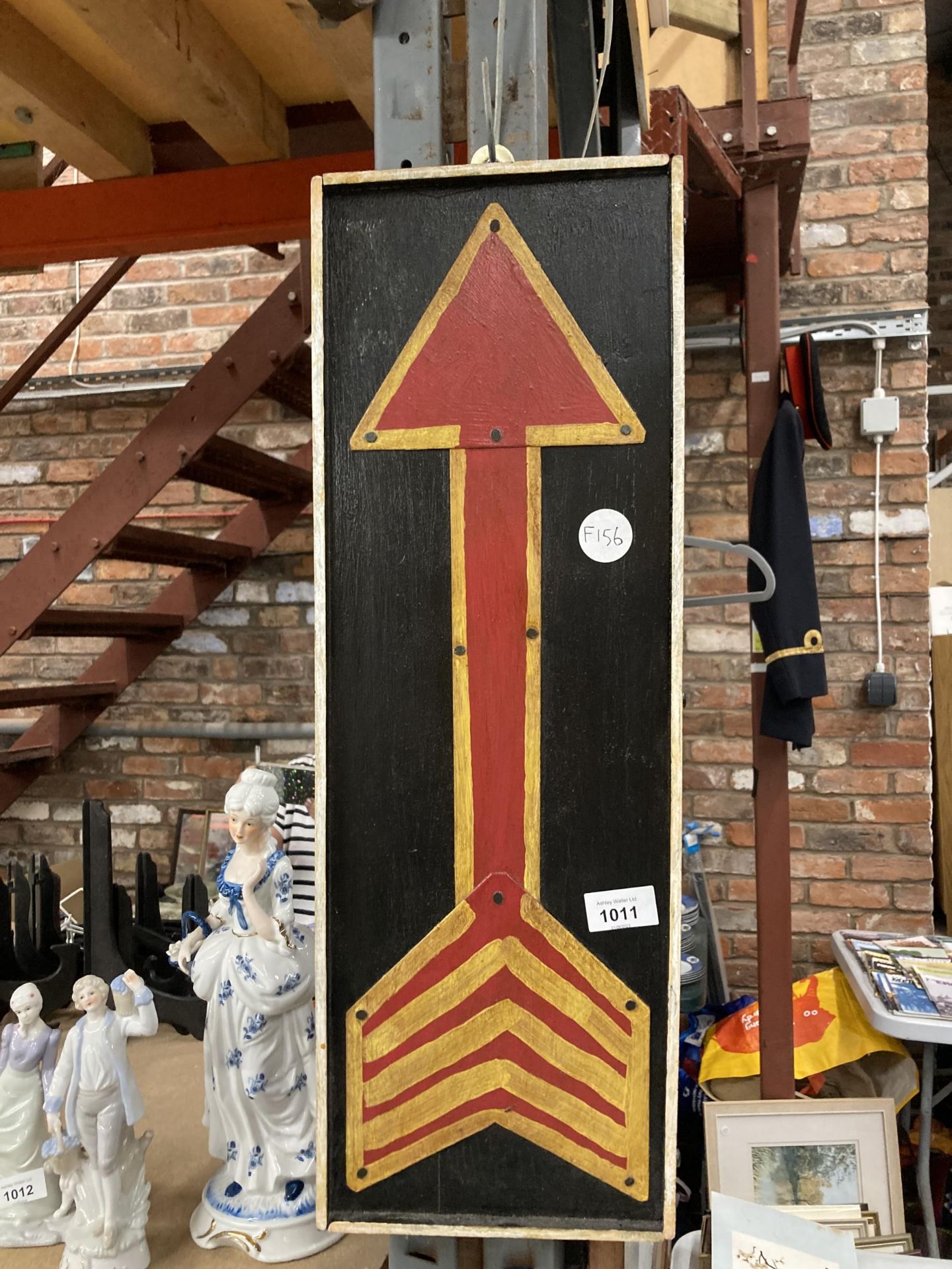 A HANDPAINTED WOODEN ARROW SIGN