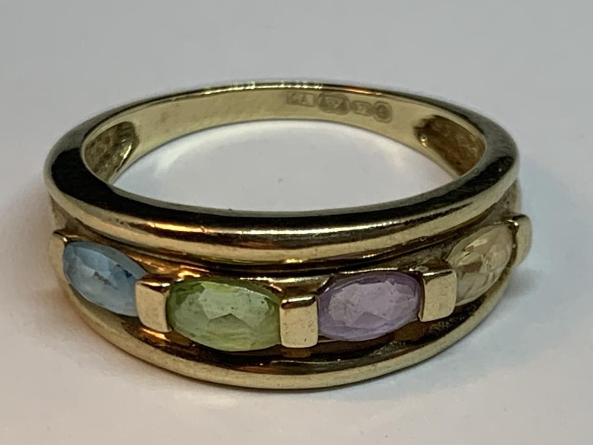 A 9 CARAT GOLD RING WITH FOUR IN LINE MULTI COLOURED GEMSTONES SIZE N/O