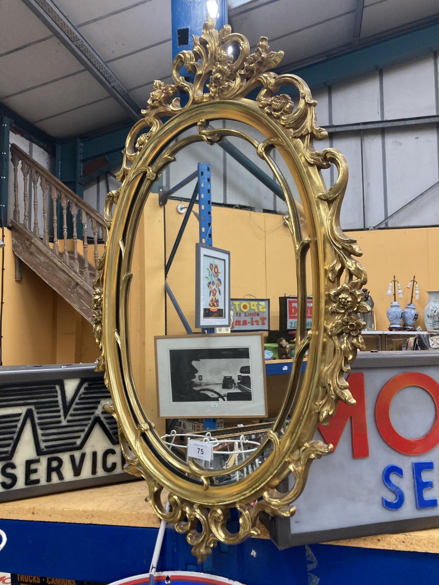 A DECORATIVE GILT FRAMED OVAL MIRROR