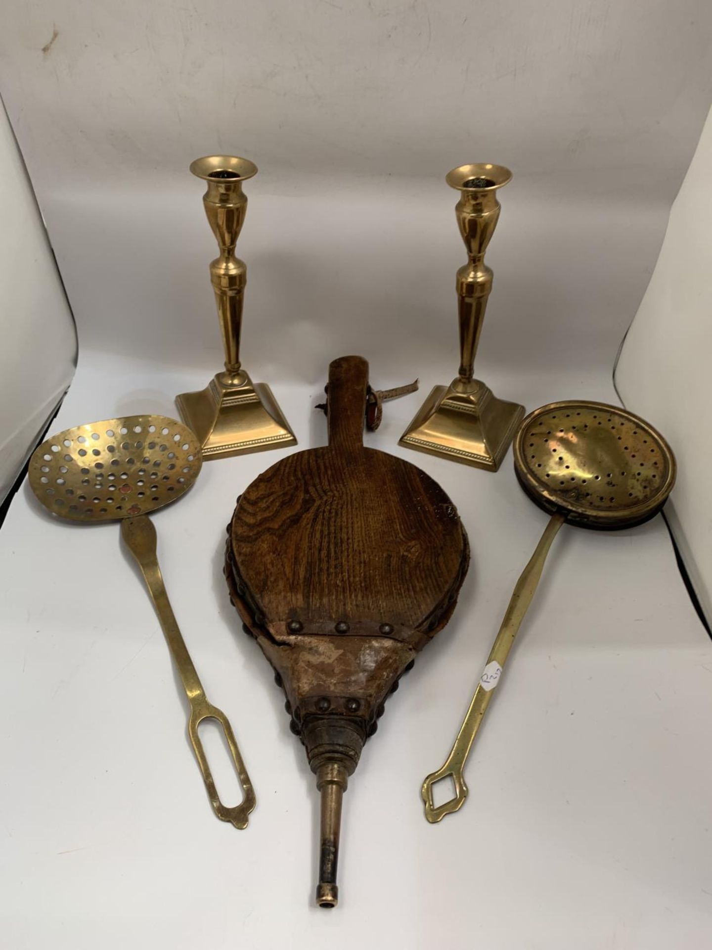 A QUANTITY OF VINTAGE BRASSWARE TO INCLUDE A PAIR OF CANDLESTICKS, CHESTNUT ROASTER, A SKILLET AND