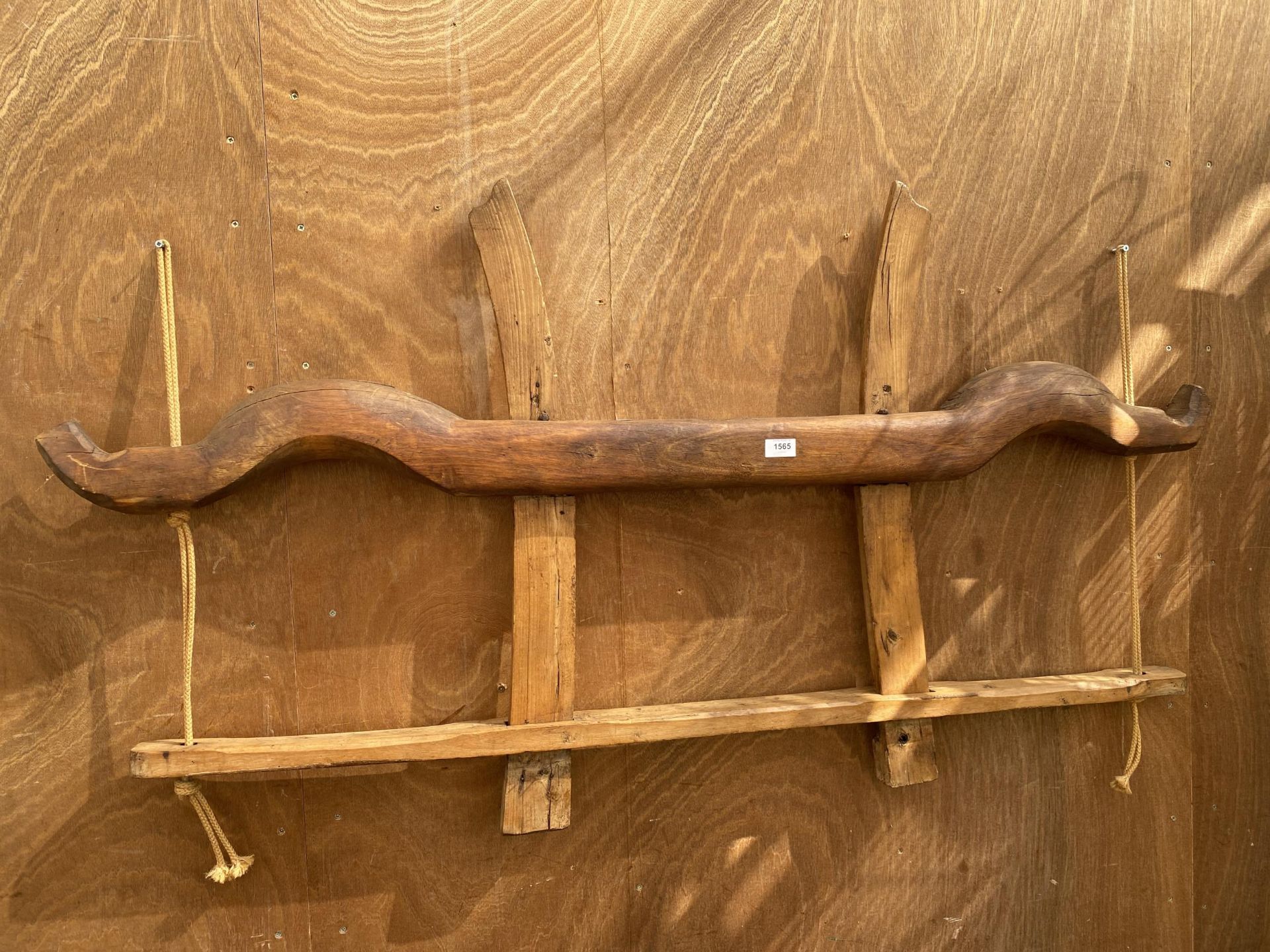 A VINTAGE WALL SHELF CREATED USING A WOODEN YOKE