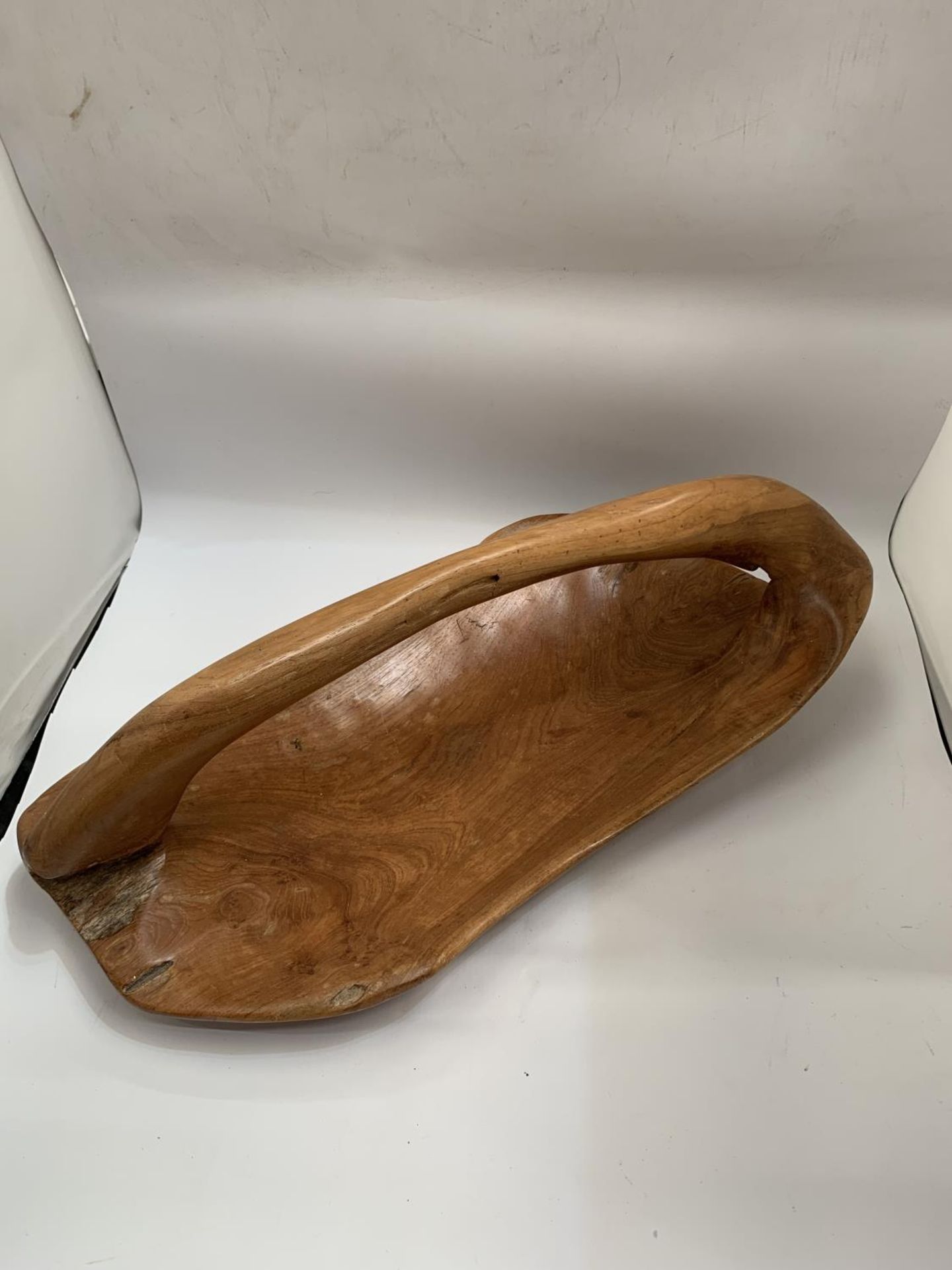 A LARGE VINTAGE HARDWOOD BOWL WITH HANDLE CARVED FROM ONE PIECE OF WOOD, LENGTH 50CM