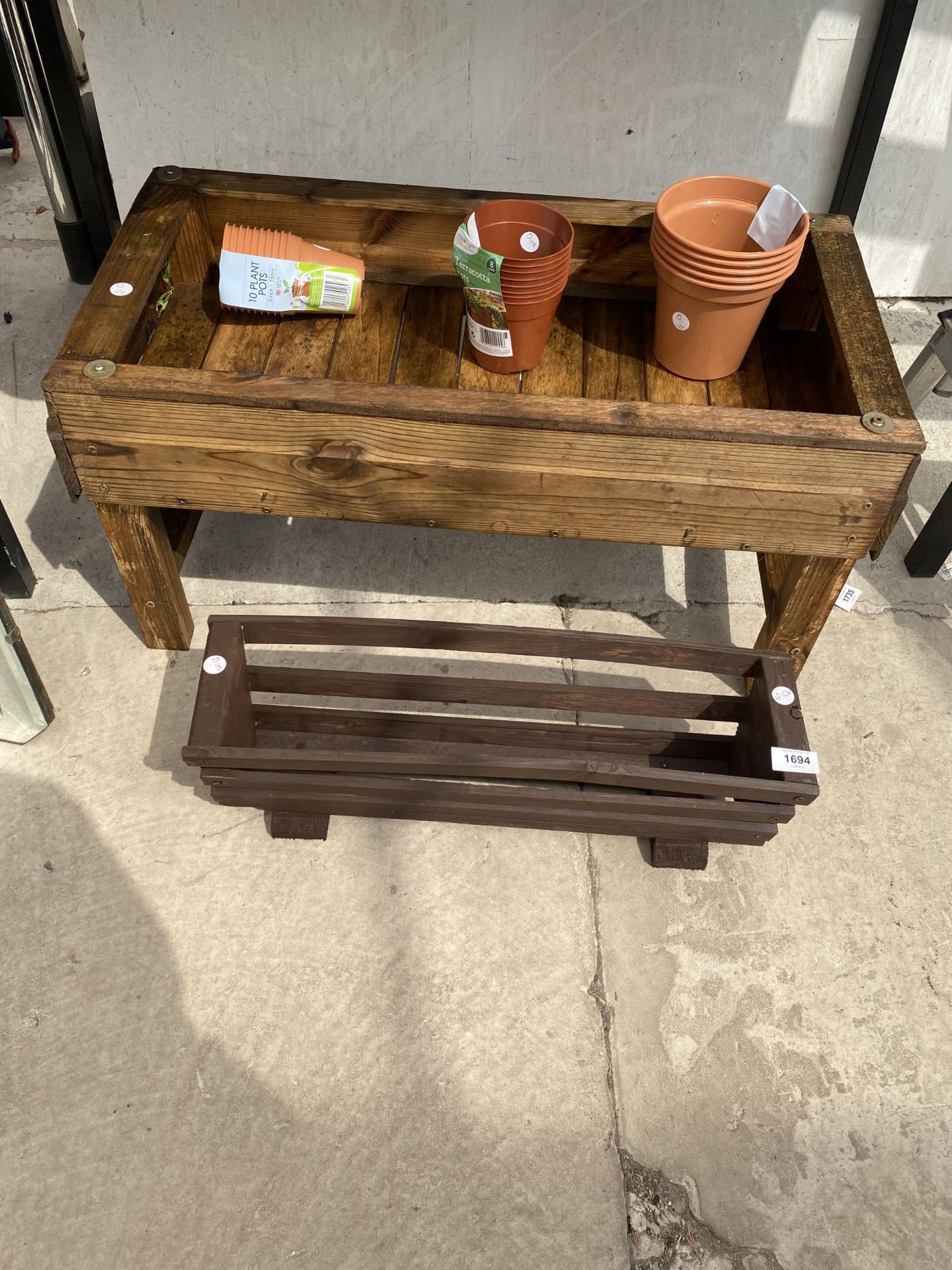A WOODEN PLANTER, A SMALL WOODEN TROUGH AND VARIOUS PLASTIC PLANT POTS