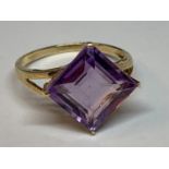 A 10 CARAT GOLD RING WITH A PURPLE DIAMOND SHAPED STONE SIZE O