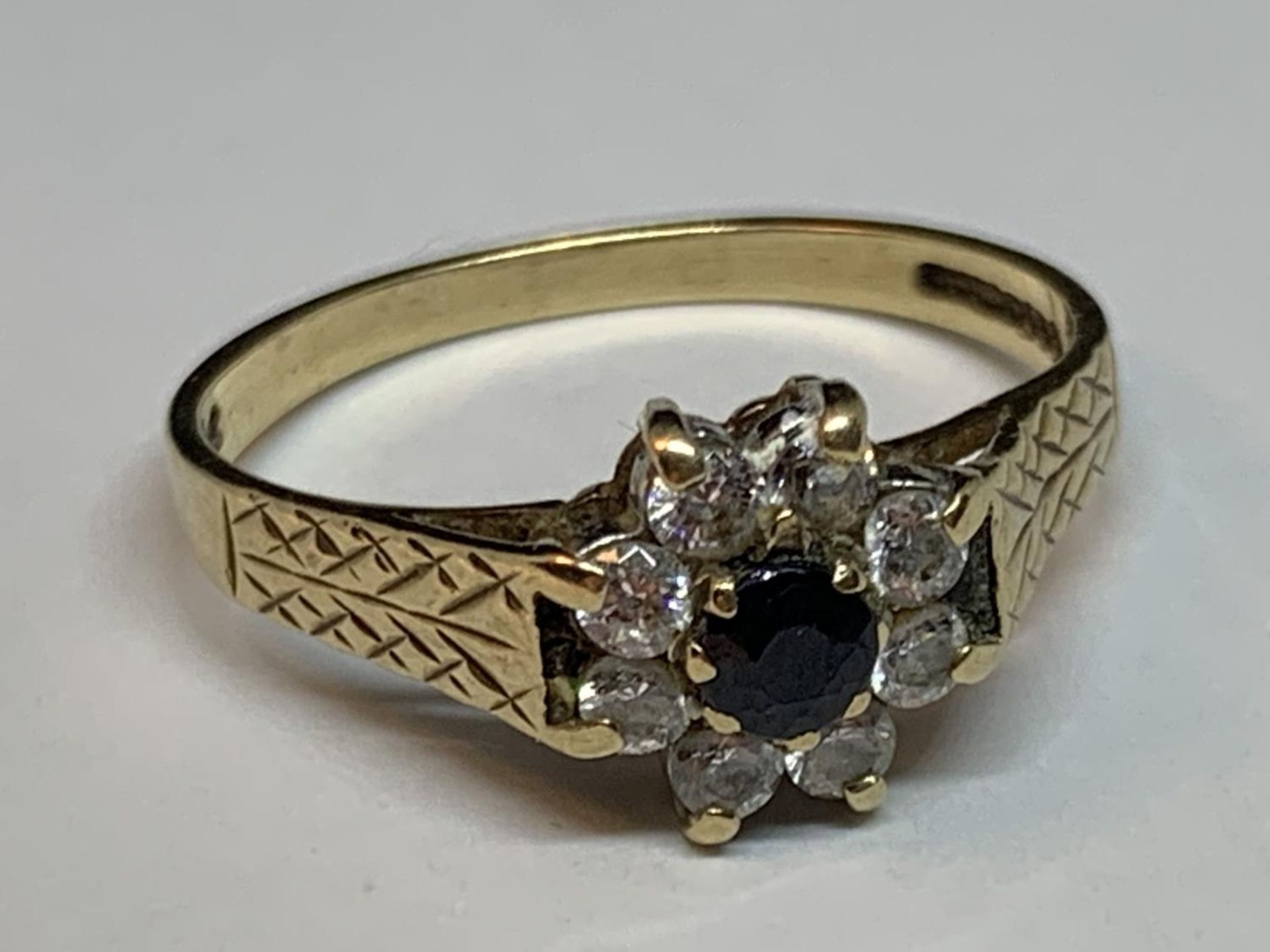 A 9 CARAT GOLD RING WITH CENTRE SAPPHIRE SURROUNDED BY CUBIC ZIRCONIA SIZE N/O