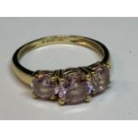 A 14 CARAT GOLD RING WITH THREE IN LINE PINK STONES SIZE M/N