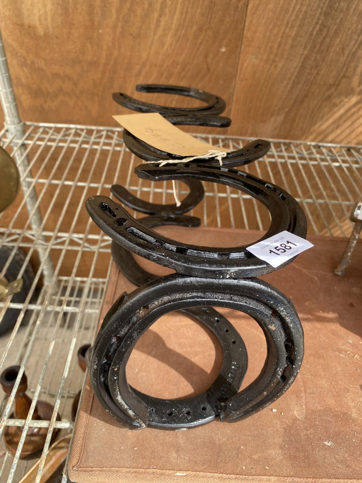 A THREE BOTTLE WINE HOLDER FORMED FROM HORSE SHOES