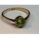 A 9 CARAT GOLD RING WITH A GREEN STONE SOLITARE SIZE N/O