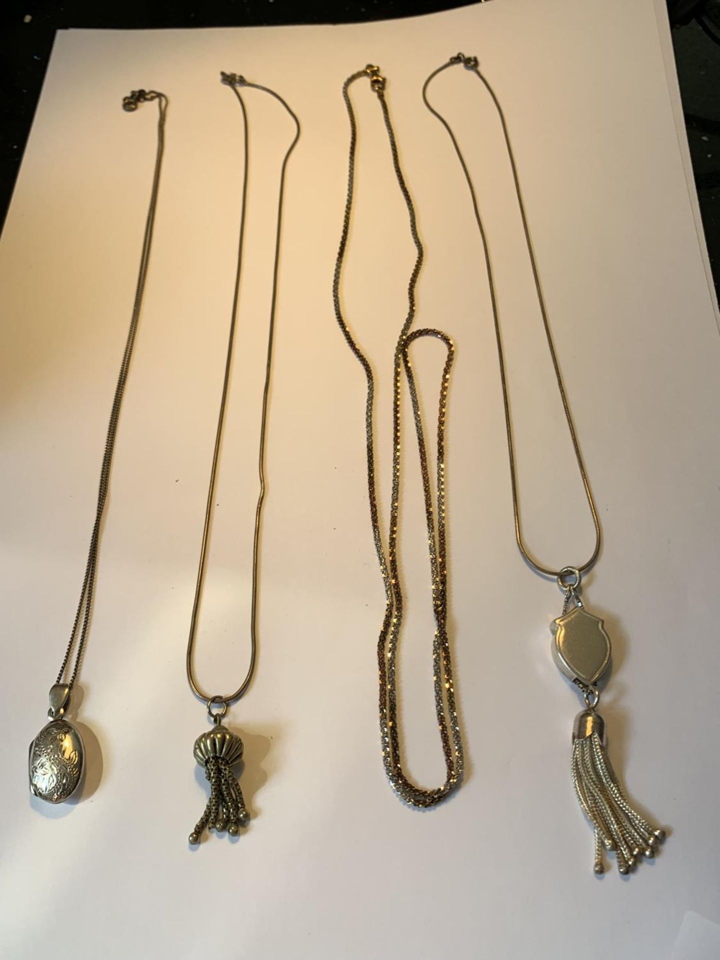 FOUR SILVER NECKLACES WITH THREE WITH PENDANTS