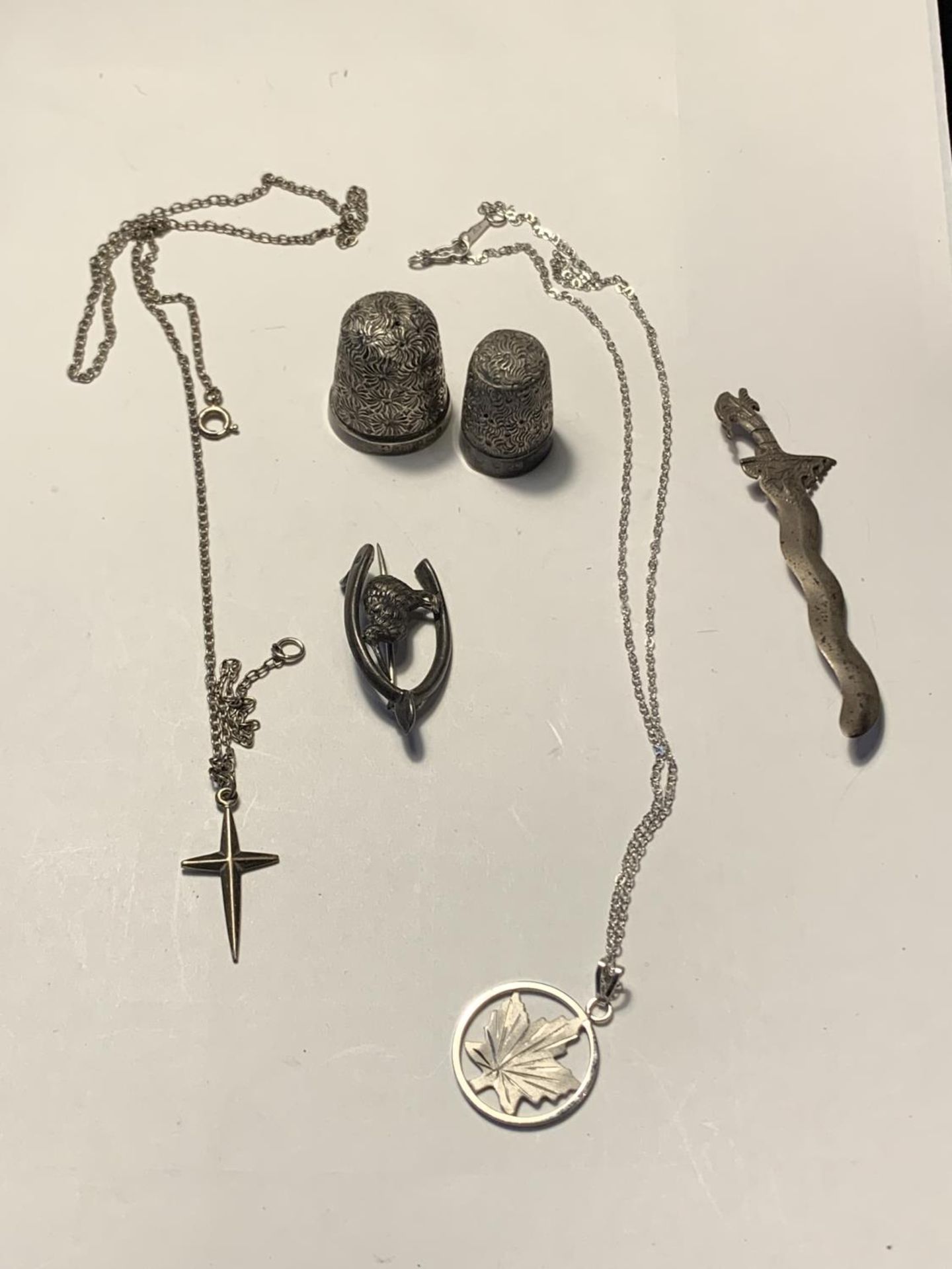 SIX ITEMS OF SILVER TO INCLUDE TWO THIMBLES, TWO BROOCHES AND TWO NECKLACES WITH PENDANTS