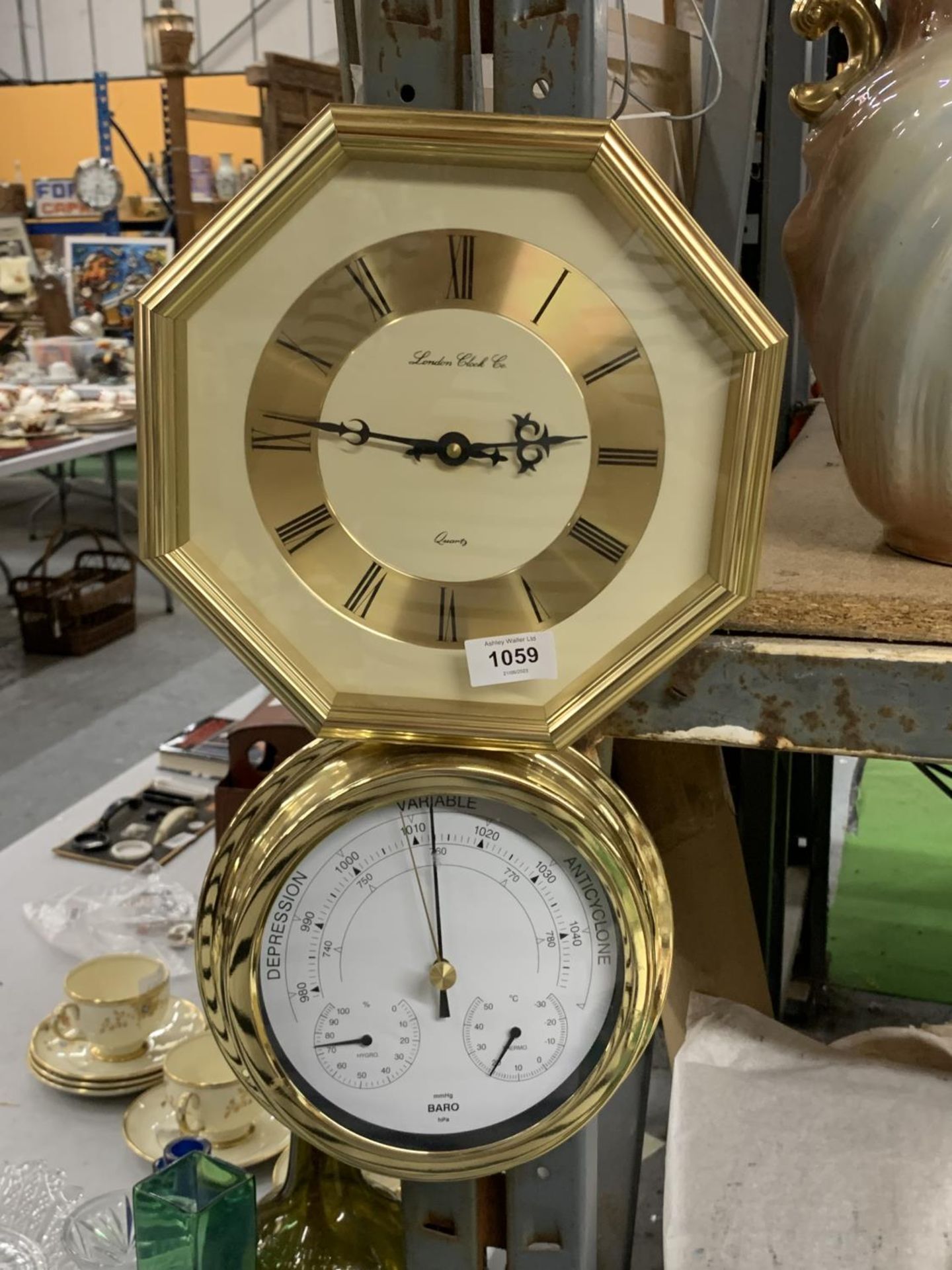 AN OCTAGONAL WALL CLOCK PLUS A BRASS STYLE ROUND BAROMETER