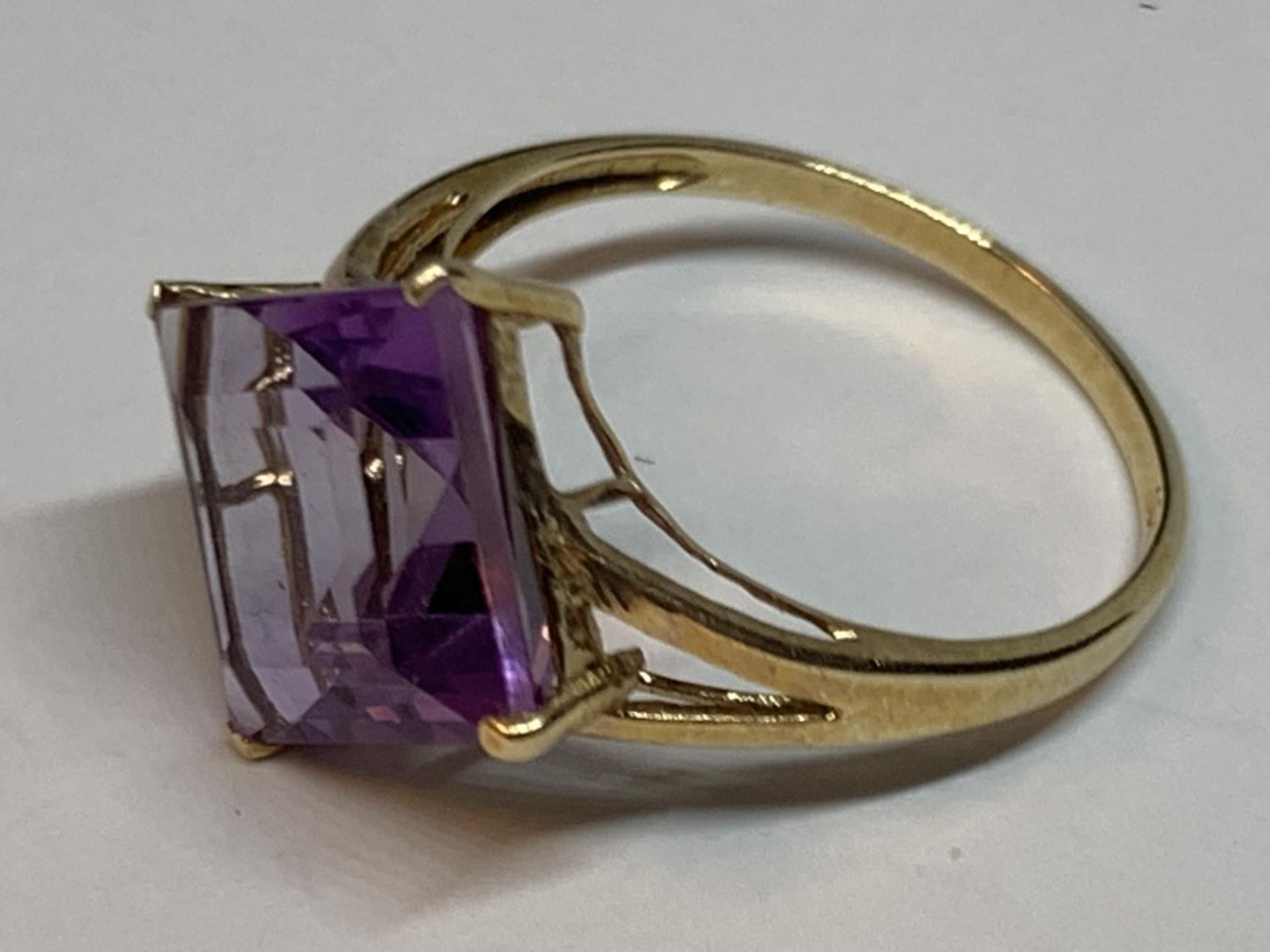 A 10 CARAT GOLD RING WITH A PURPLE DIAMOND SHAPED STONE SIZE O - Image 2 of 3