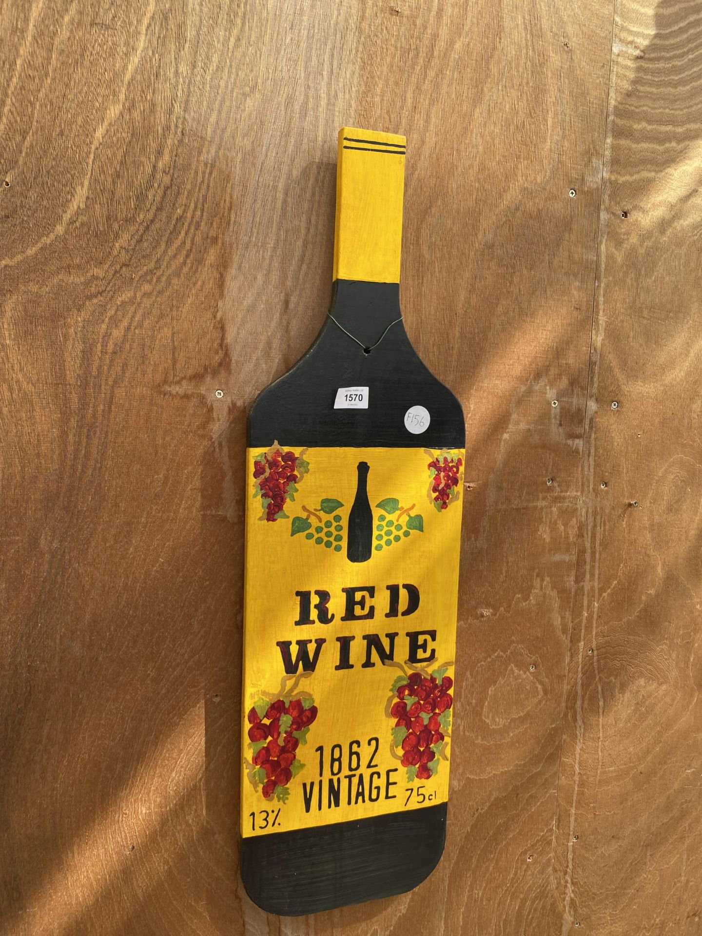 A WOODEN HAND PAINTED RED WINE BOTTLE SIGN