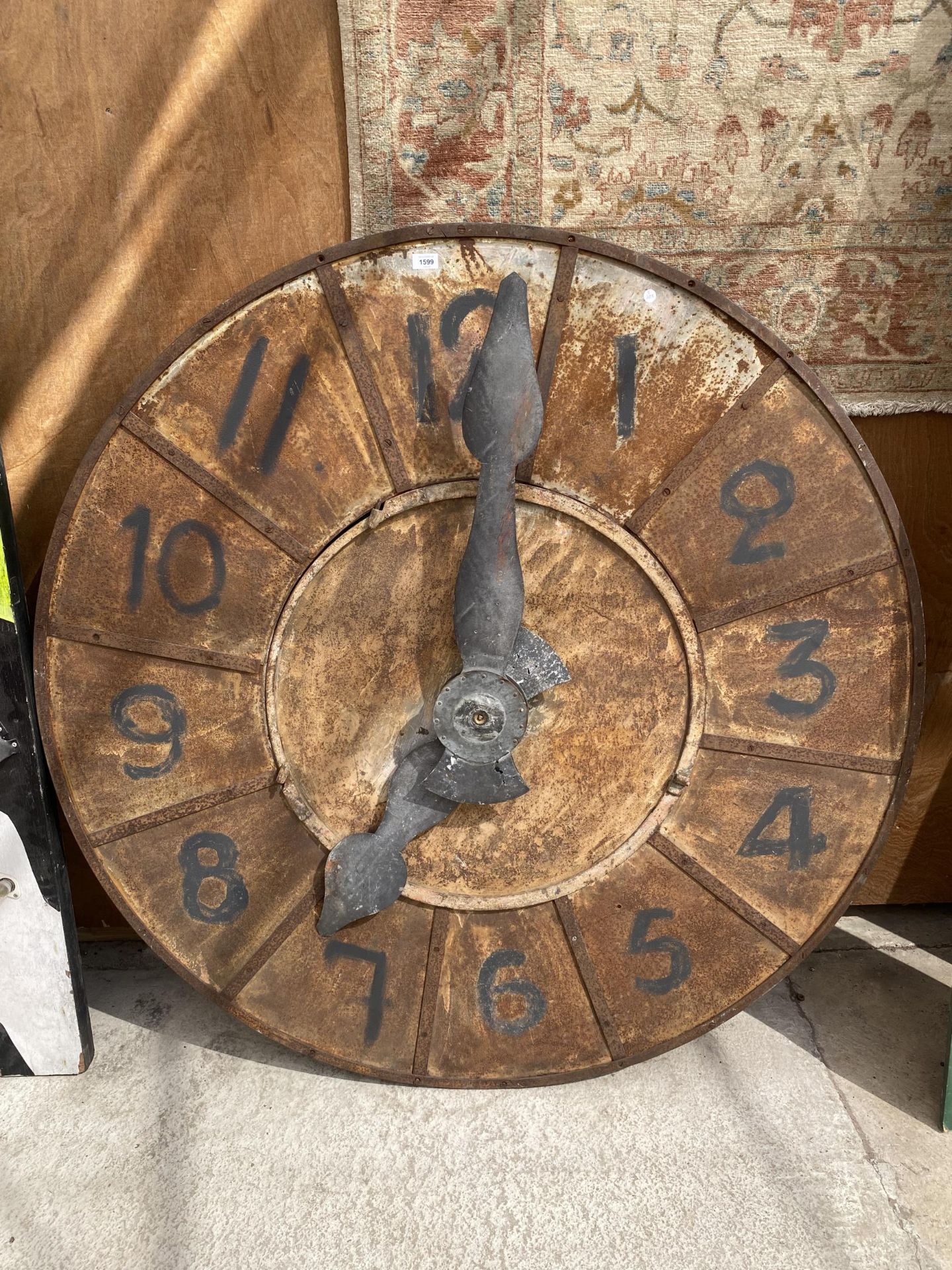 A VINTAGE METAL AND WOODEN LARGE FRENCH CLOCK COMPLETE WITH WORKINGS