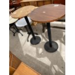 TWO TALL PUB TABLES, 24 AND 26" DIAMETER, ON BLACK METALWARE BASES