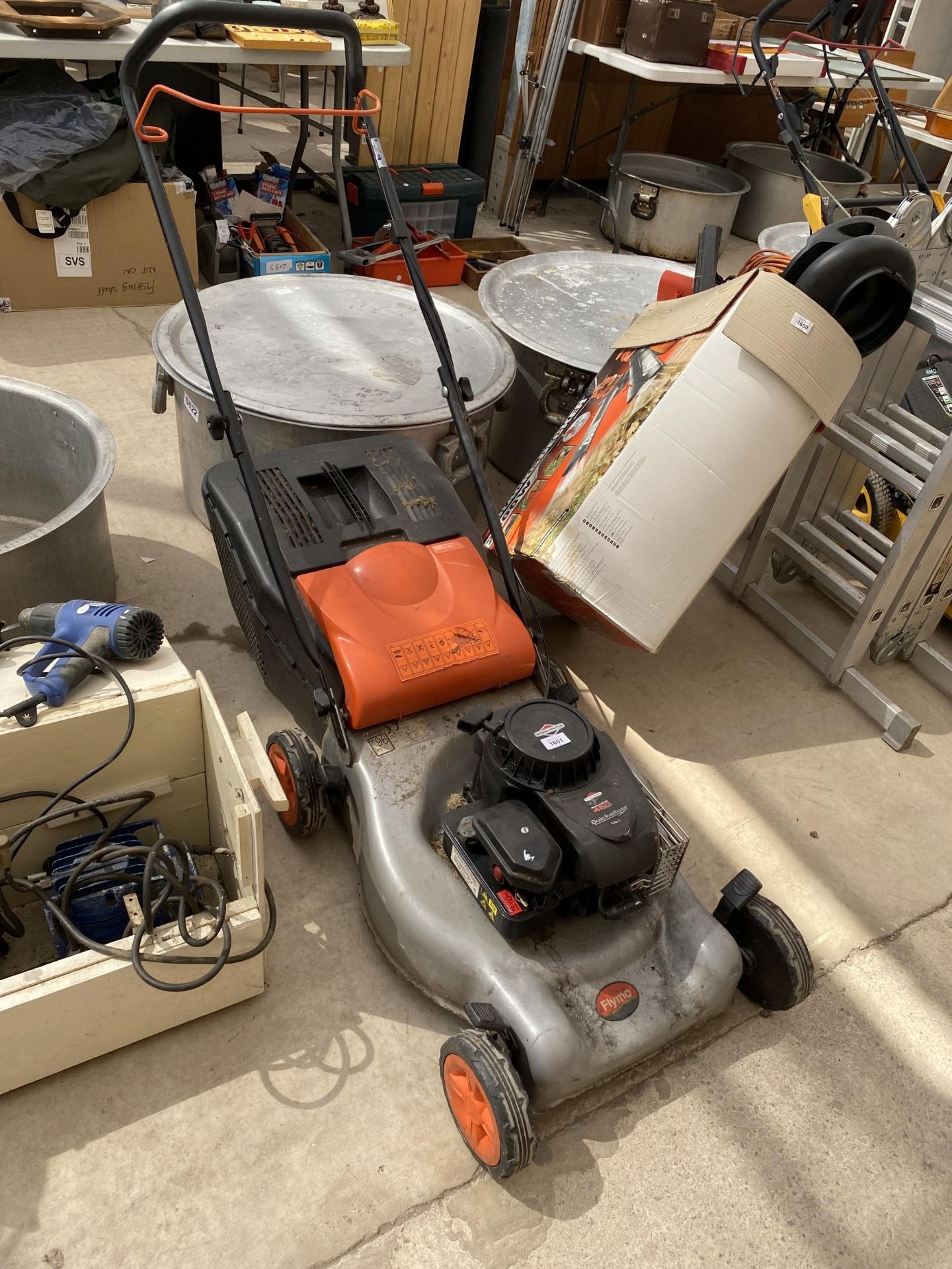 A FLYMO PETROL LAWN MOWER WITH A BRIGGS AND STRATTON ENGINE AND WITH GRASS BOX, BELIEVED IN