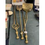 FOUR LARGE PIECES OF BRASSWARE TO INCLUDE A POKER, TONGS, SKILLET AND SHOVEL