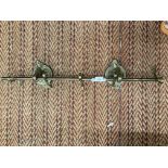 A VINTAGE BRASS CURTAIN POLE WITH HORSE HEAD BRACKETS