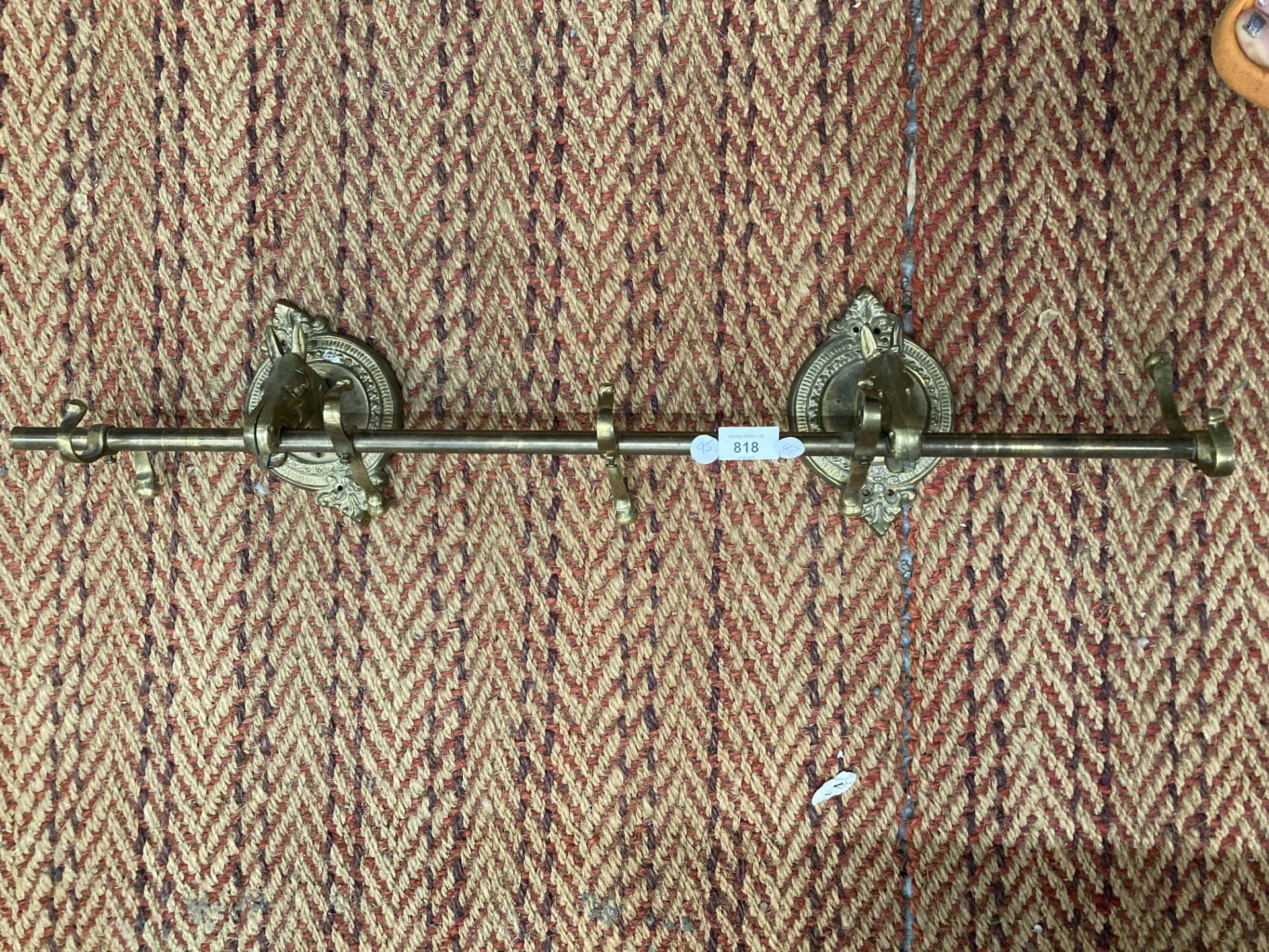 A VINTAGE BRASS CURTAIN POLE WITH HORSE HEAD BRACKETS