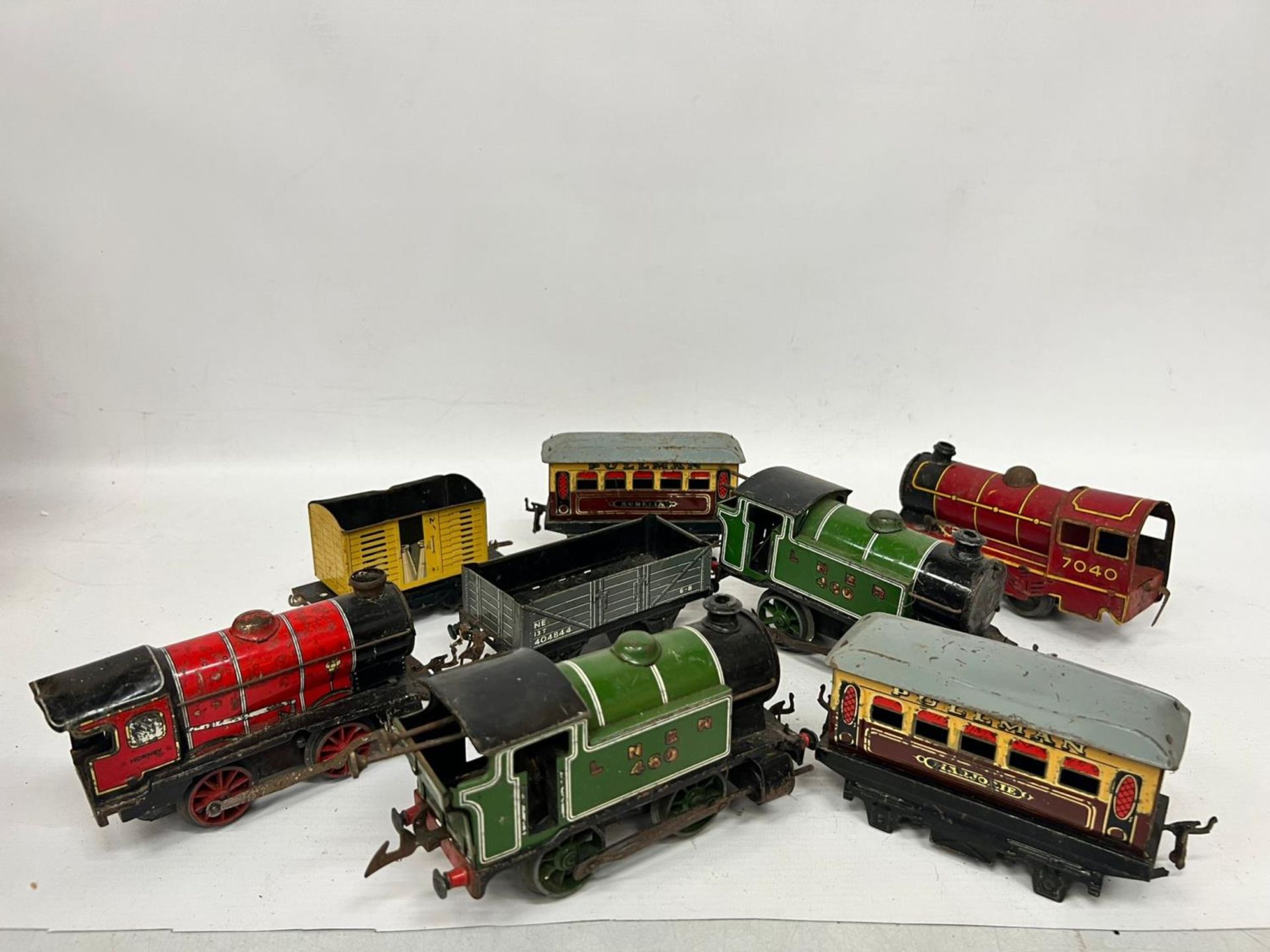 EIGHT O GAUGE MODEL RAILWAY ROLLING STOCK - FOUR CLOCKWORK LOCOMOTIVES, TWO PULLMAN CARRIAGES AND