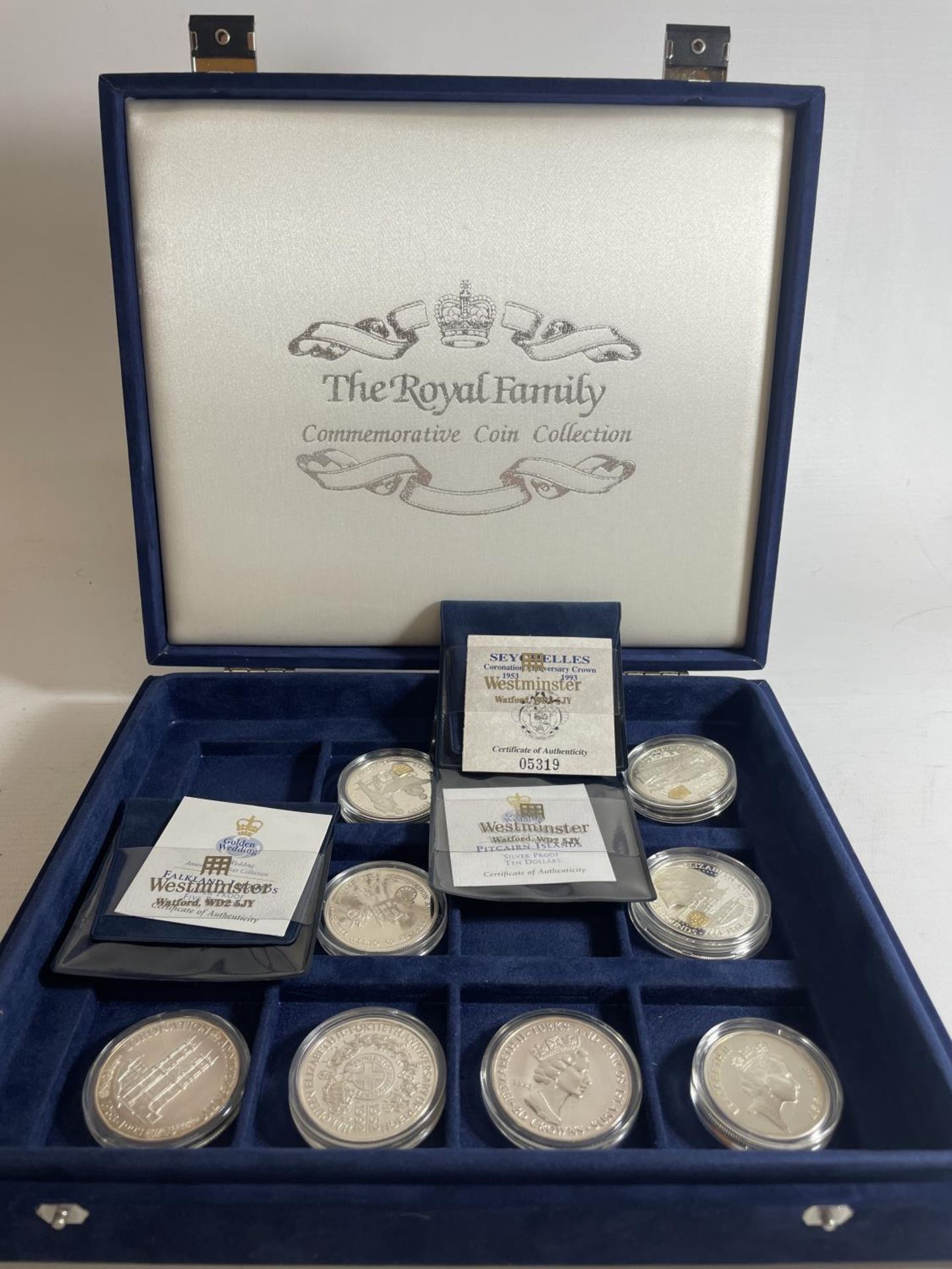 PRESENTATION CASE HOUSING ROYAL FAMILY COMMEMORATIVE COINS TO INCLUDE : PITCAIRN, FALKLANDS,