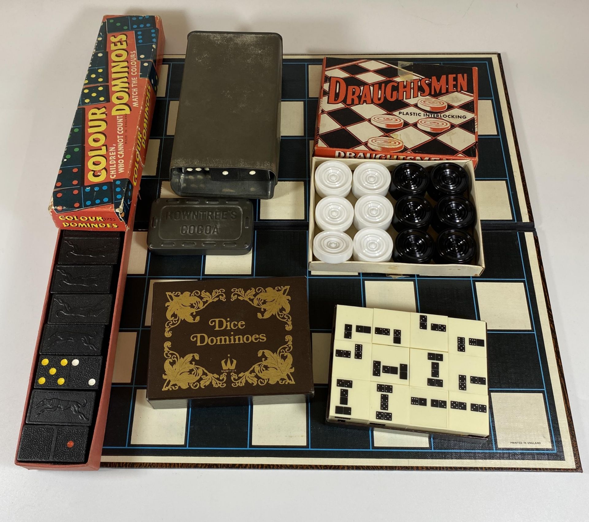 A MIXED GAMES LOT TO INCLUDE BOXED DRAUGHTMEN SET, DICE DOMINOES, ROWNTREES COCOA TIN ETC